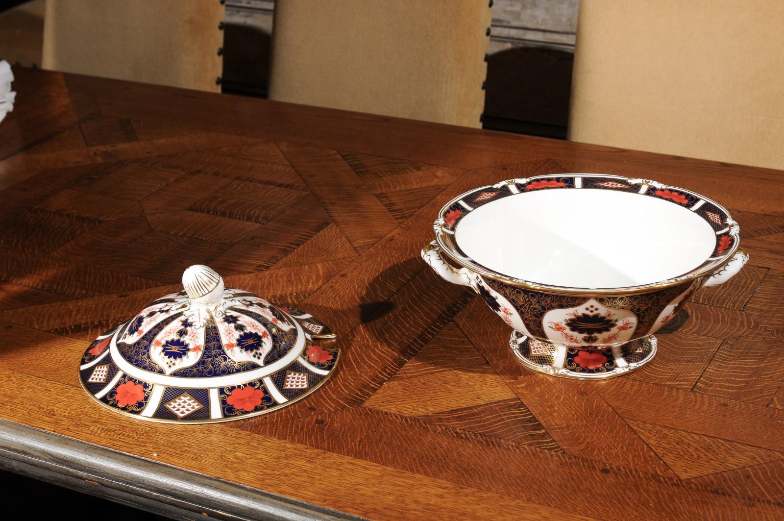 An English Royal Crown Derby Porcelain Old Imari pattern tureen with delicate finial. Born in England in 1993, this lovely soup tureen was produced by the Royal Crown Derby Porcelain company, famous for its high quality bone china. Adorned with the