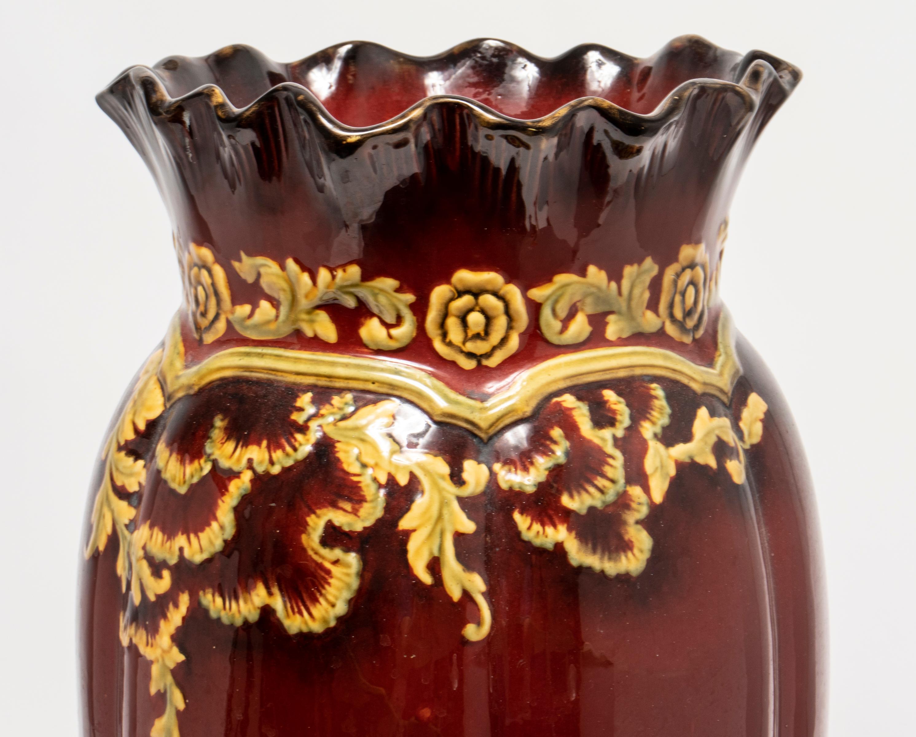 Ruby ware English glazed pottery umbrella stand, in the style of Royal Doulton, red ground with yellow floral motif decoration, in the Arts & Crafts or Art Nouveau taste, maker's marks underside. Measures: 21.5