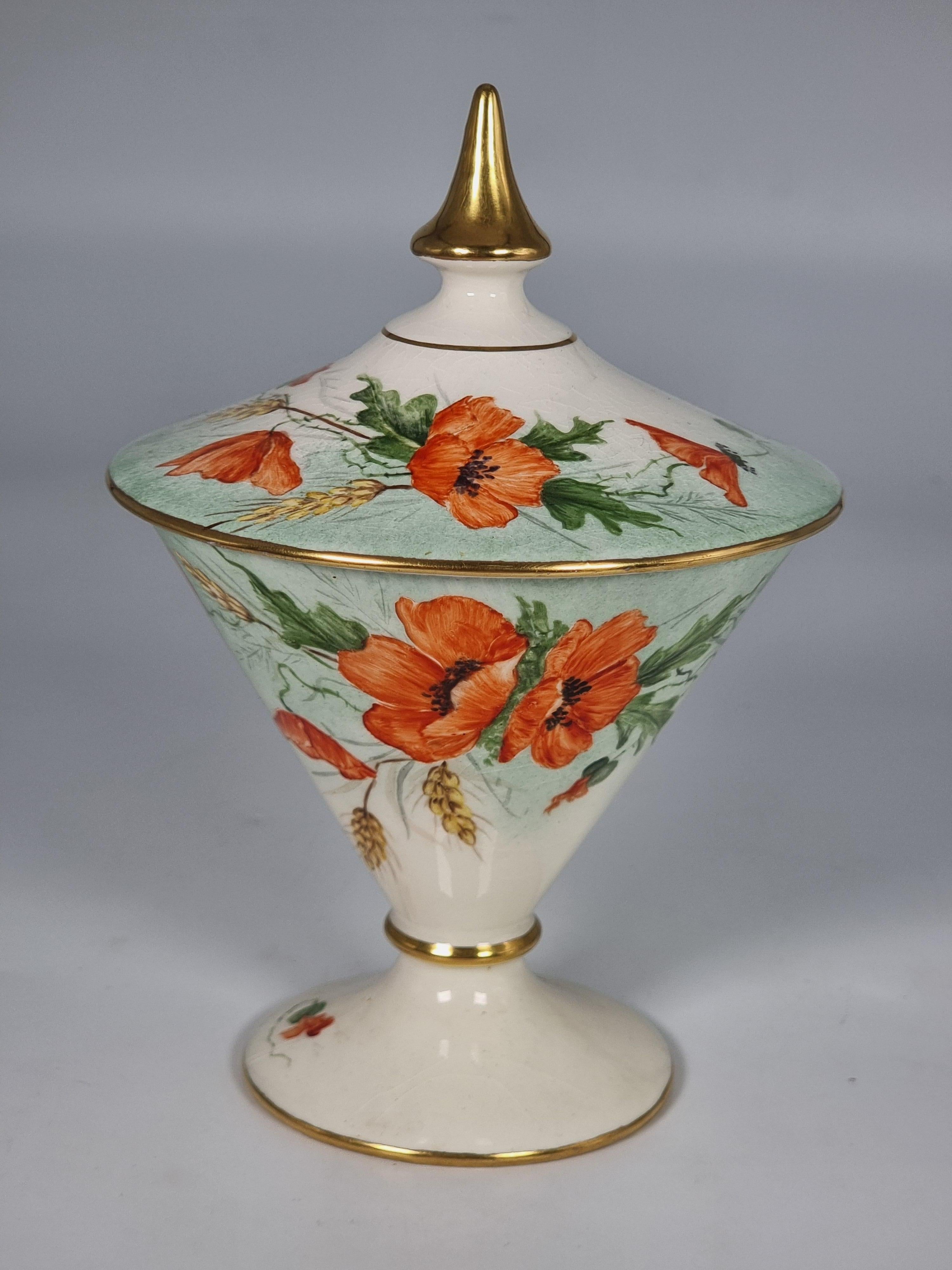 A most unusual and stylish  1930s Royal Winton hand painted Art Deco vase and cover. The vase and cover are hand painted with sprays of English poppies and golden corn celebrating mid-summer warmth.

This fine piece is finished with rich gilding to