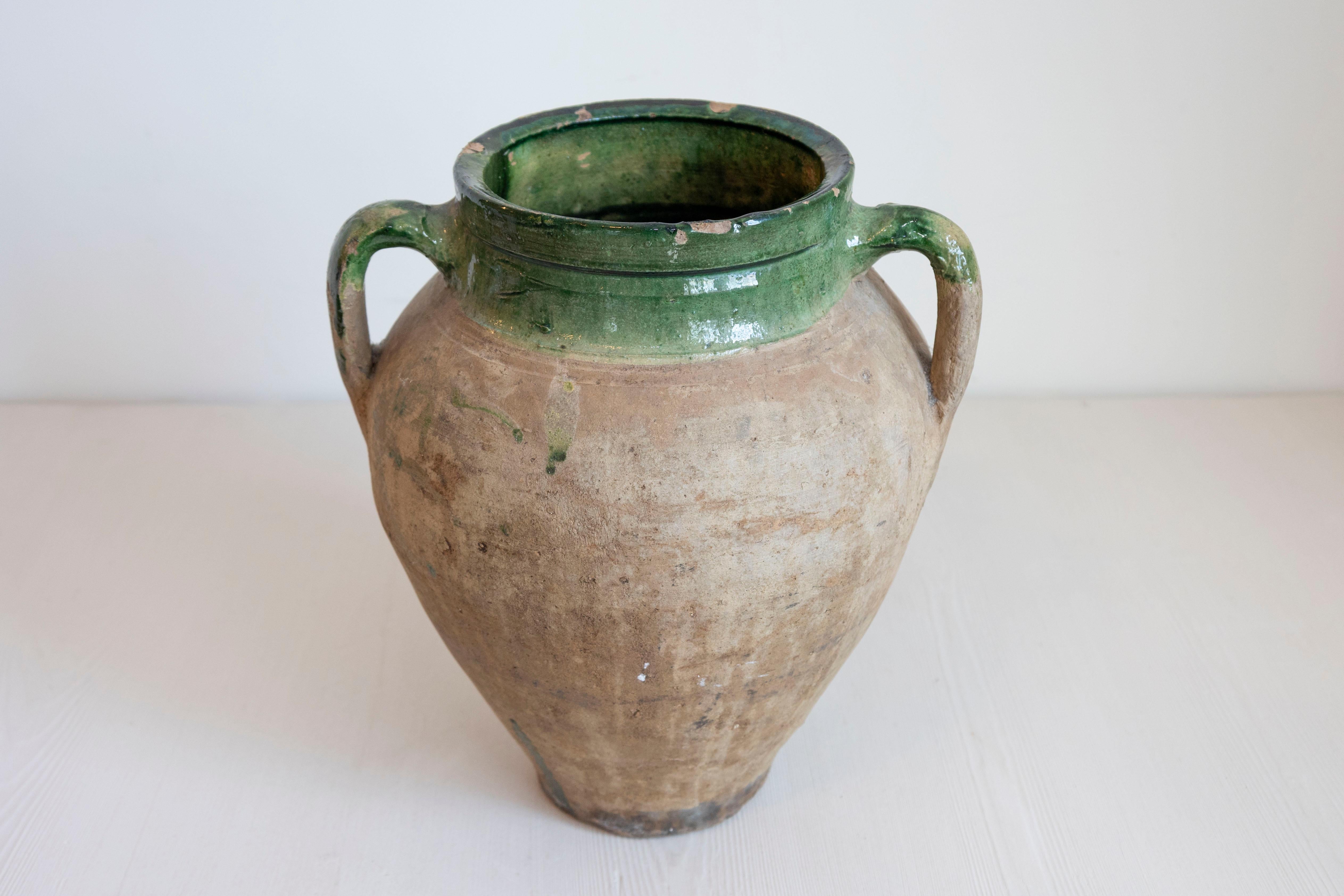 Un orcio in terracotta inglese del 1930 circa con smalto verde, due manici e carattere rustico. Scopri l'eleganza rustica di questo vaso da olio in terracotta inglese, risalente al 1930 circa, un pezzo ricco di storia e carattere. Questo vaso