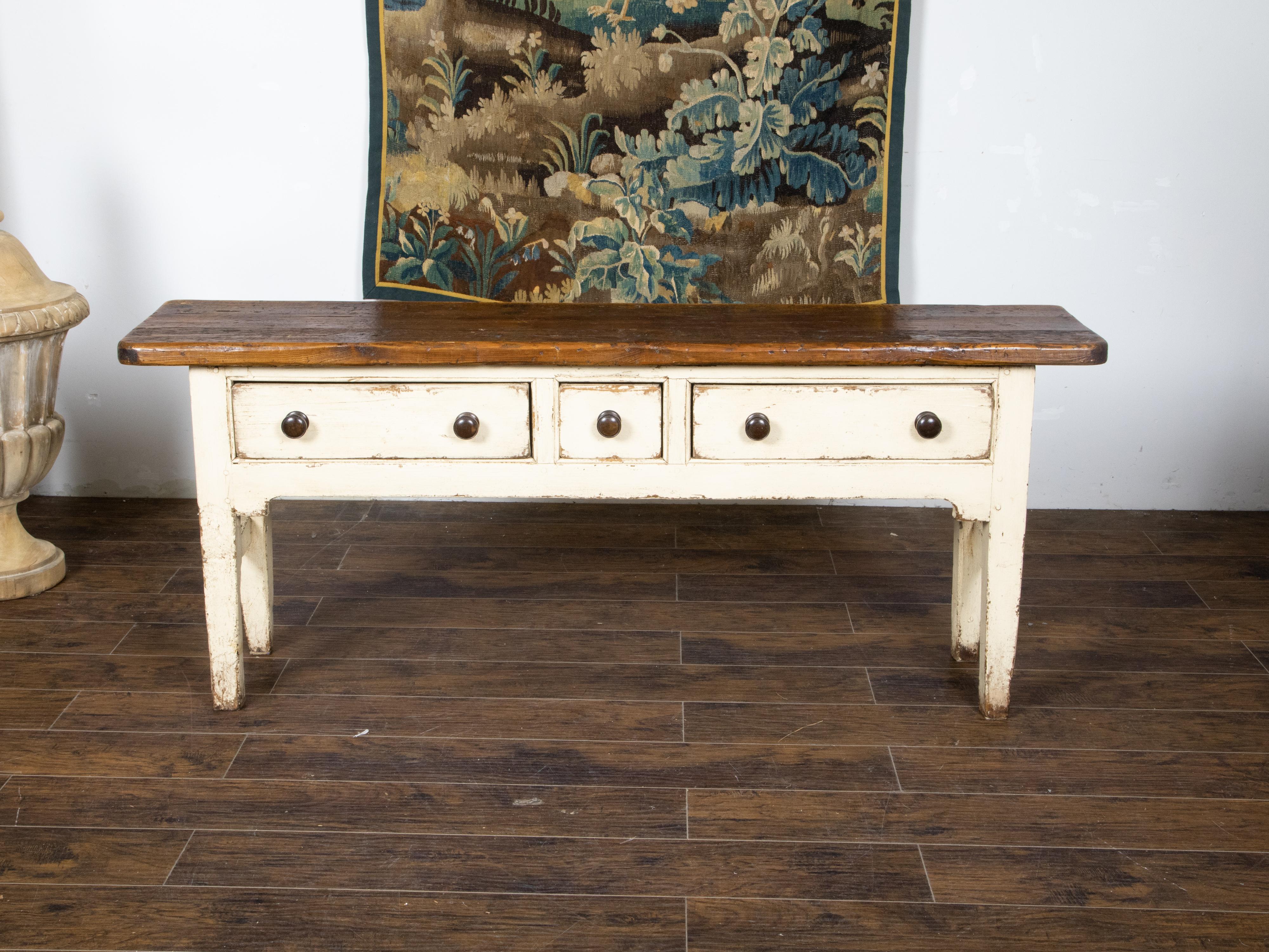 An English console or sofa table from the 20th century, with brown top, cream painted base, three drawers and great rustic character. Created in England during the 20th century, this table features a nicely distressed rectangular brown wood planked