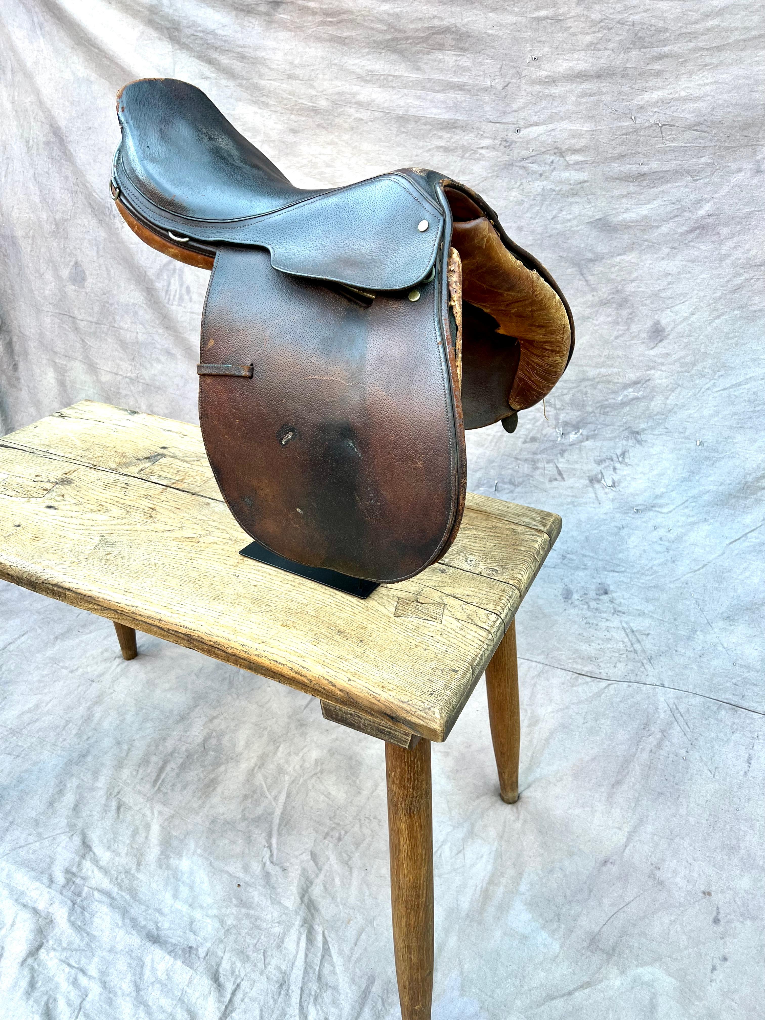 A wonderful English riding saddle in leather - a compliment to many interiors especially those with a Rustic or Ralph Lauren environment. The piece comes on a stand and works well with many groupings. While the saddle may be practical and working,