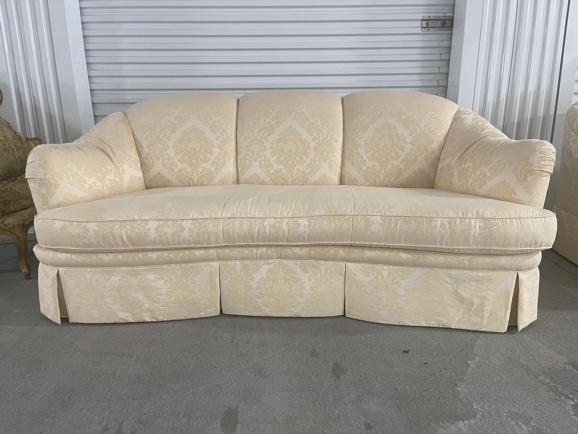 20th Century English scalloped style arm sofa with a serpentine front and upholstered in off white damask.