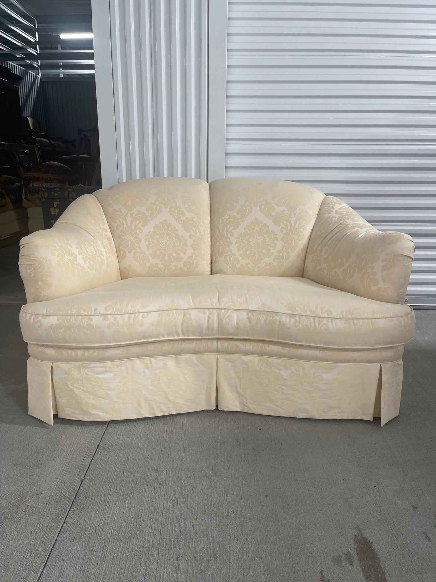 20th Century English Scalloped Style Loveseat with a Serpentine Front and Upholstered in Off White Damask.