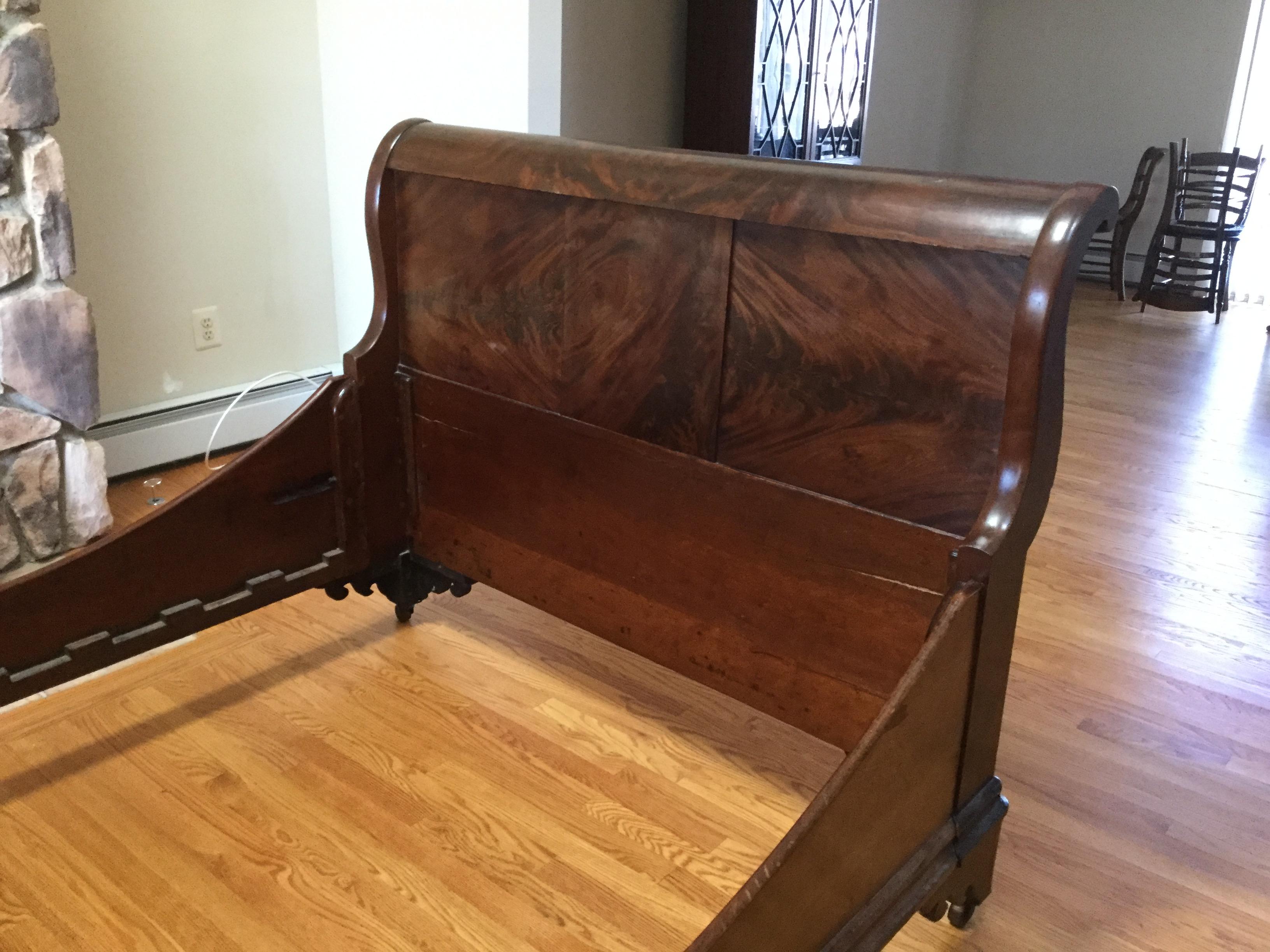 Handsome and elegant describe this early 20th century English/Scottish sleigh bed. Made of flame-mahogany, this bed will accommodate a full mattress. The head and footboard are of the same height and the side rails are both finished and very
