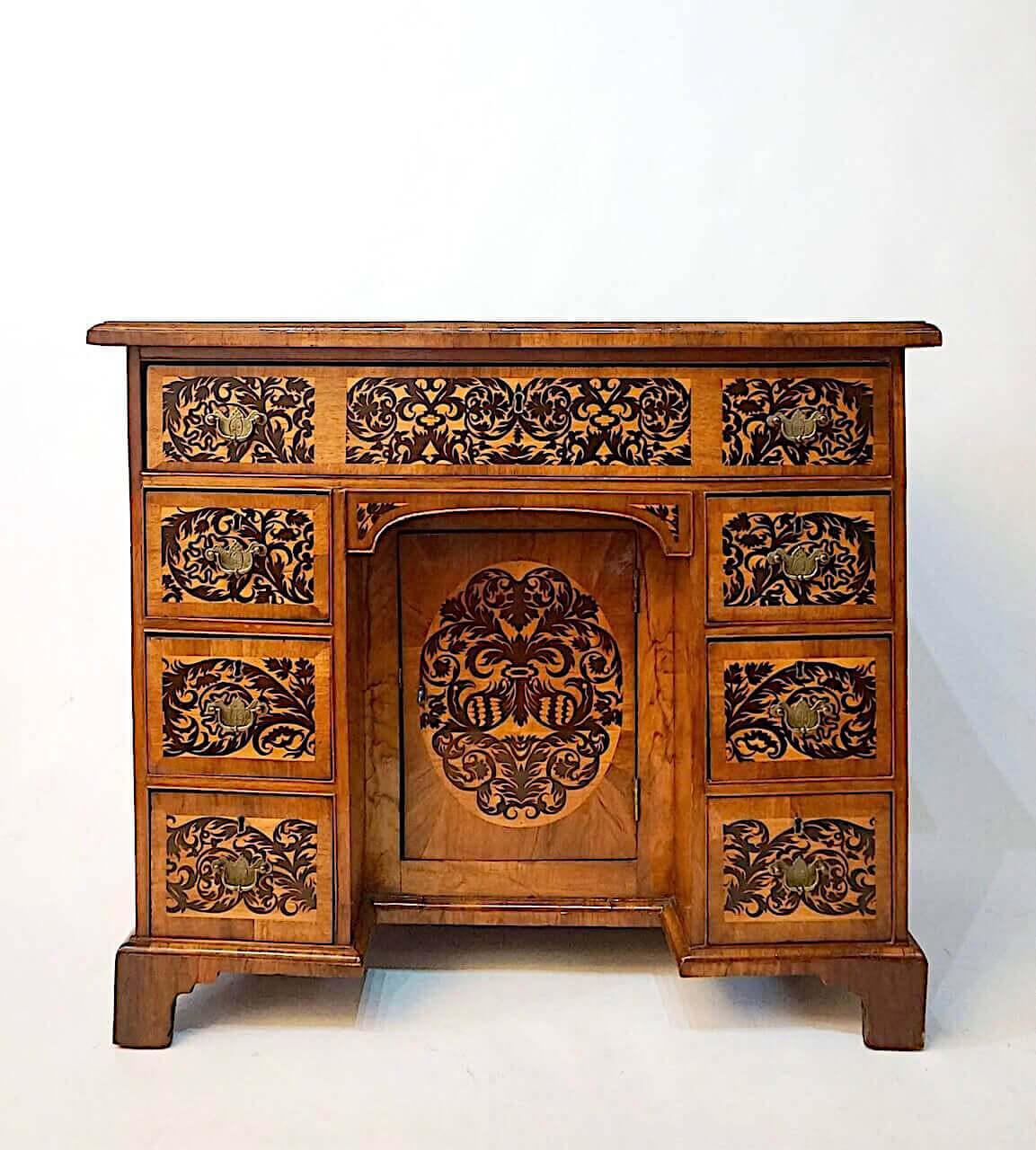 An exquisite circa 1735 English George II 'bureau table' or 'knee-hole desk' incorporating circa 1690 William and Mary 'arabesque' or 'seaweed' marquetry elements in the style of Gerrit Jensen, the ovolo moulded rectangular top inlaid with ebony