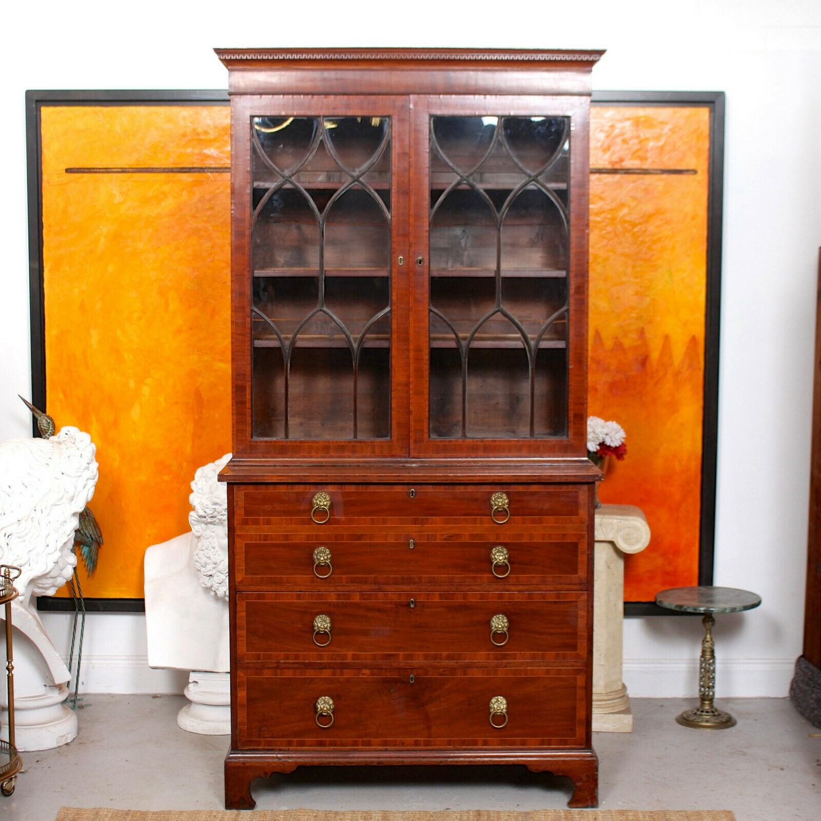 An attractive 19th century inlaid mahogany glazed secretaire.

The mahogany boasting a well figured flamed grain and rich patina.

The upper section with a carved cornice above astragal glazed doors enclosed adjustable shelving. The lower