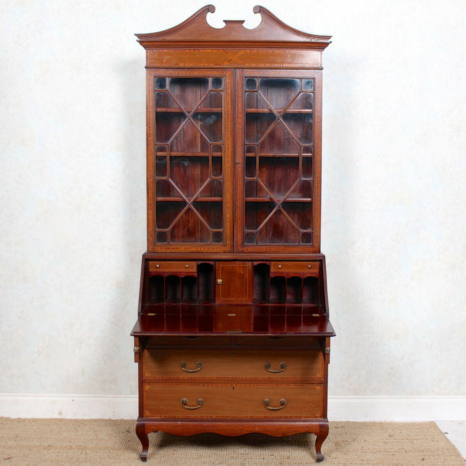 An attractive Edwardian satinwood banded inlaid mahogany glazed secretaire.

The mahogany boasting a well figured flamed grain and rich patina.

The upper section with a built-in arched scroll pediment above double astragal glazed doors enclosed