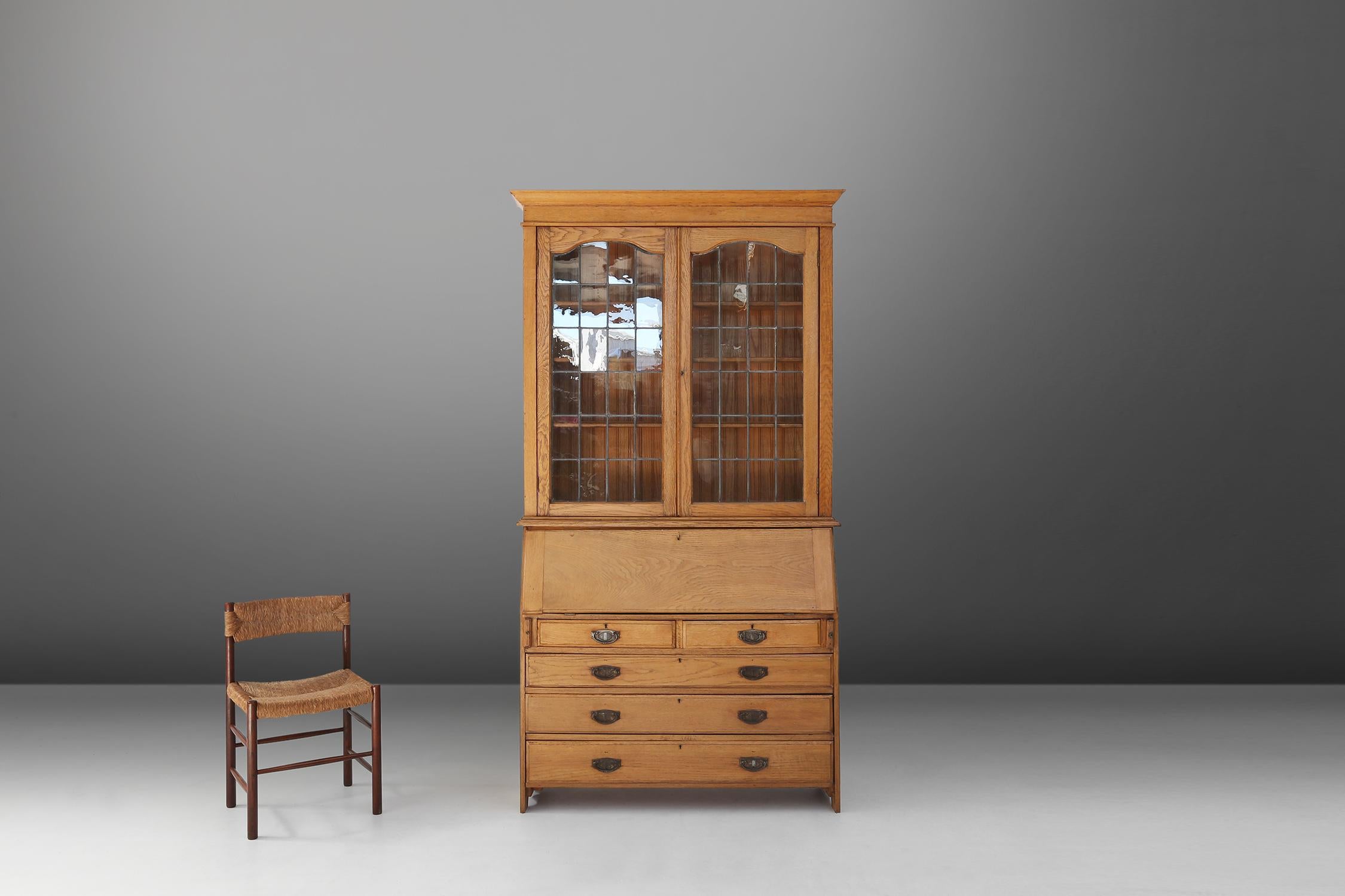 Dieses englische Sekretär-Bücherregal im Kunsthandwerksstil ist ein schönes Möbelstück, das sowohl Eleganz als auch Funktionalität zum Ausdruck bringt. Das Sekretariatsregal wurde um 1910 aus Eiche gefertigt, einem dauerhaften und warmen MATERIAL,