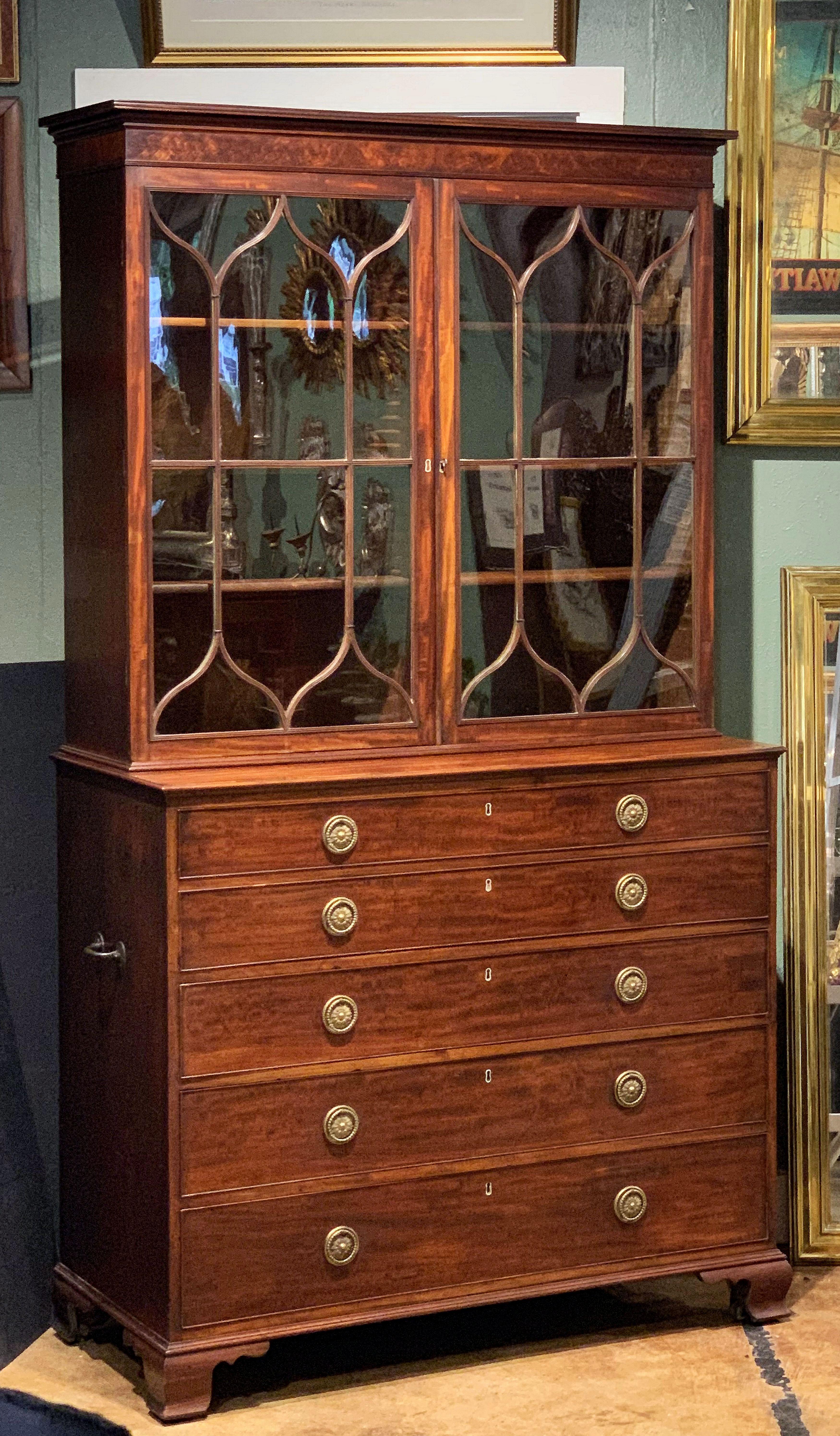 A fine English bureau bookcase or secretary (secretaire) of mahogany from the Georgian era.
The upper section featuring a shaped cornice and two astragal or lattice glass doors enclosing three adjustable shelves.
Set upon a bottom tier with fall