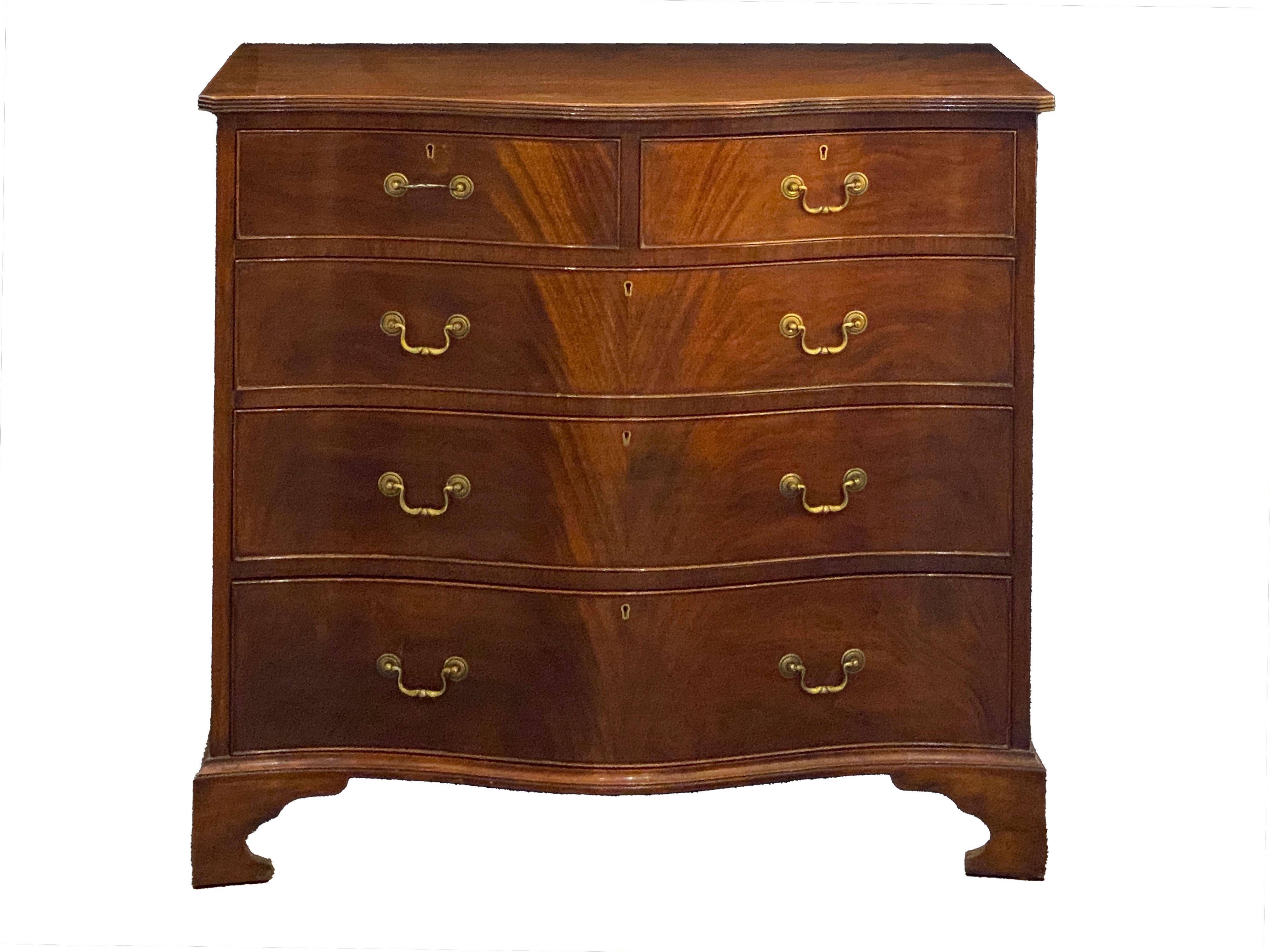Una bella cassettiera inglese di grandi dimensioni in mogano a fiamma, in stile georgiano, risalente al XIX secolo, caratterizzata da un piano sagomato con bordo ribassato, su un fregio a serpentina con due cassetti corti e tre cassetti lunghi; ogni