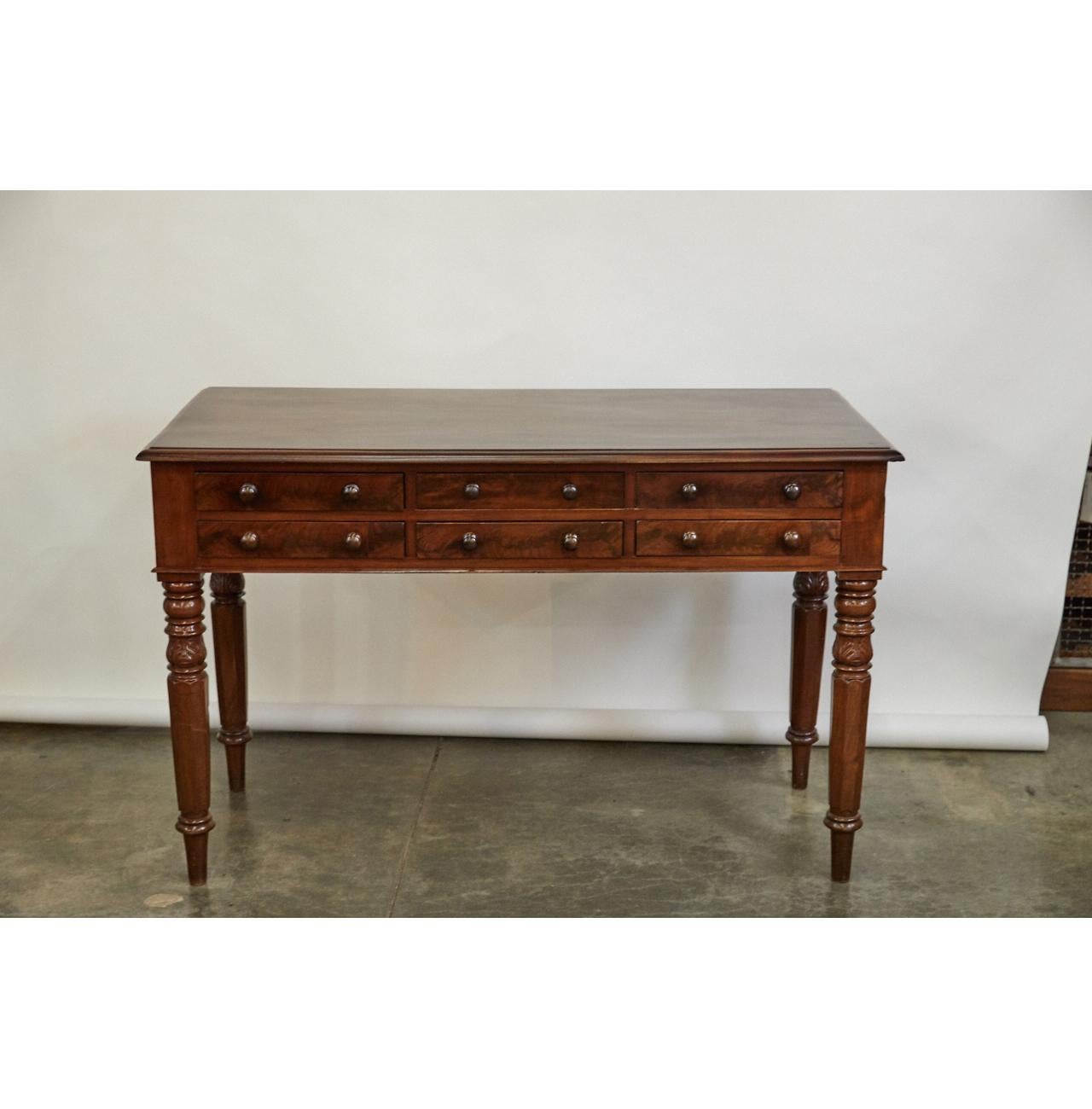 This impressive mahogany server with walnut veneer is from the first quarter of the 19th century. Made with fine craftsmanship, the piece has six drawers and intricate turned and carved tapered legs. The piece shows signs of old repairs.

     