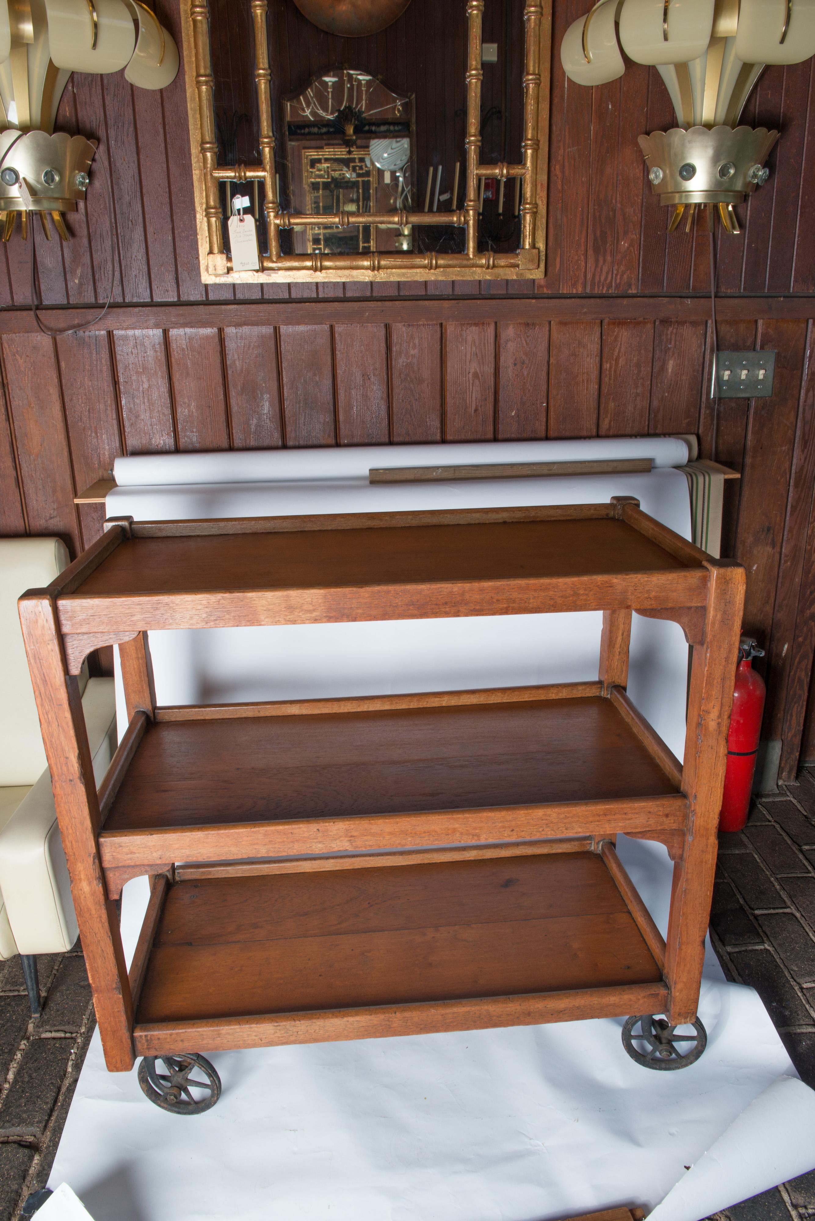 Solid wood English serving cart with original wheels. Both shelves have 14 inch clearance. Wheel diameter is 6 inches.