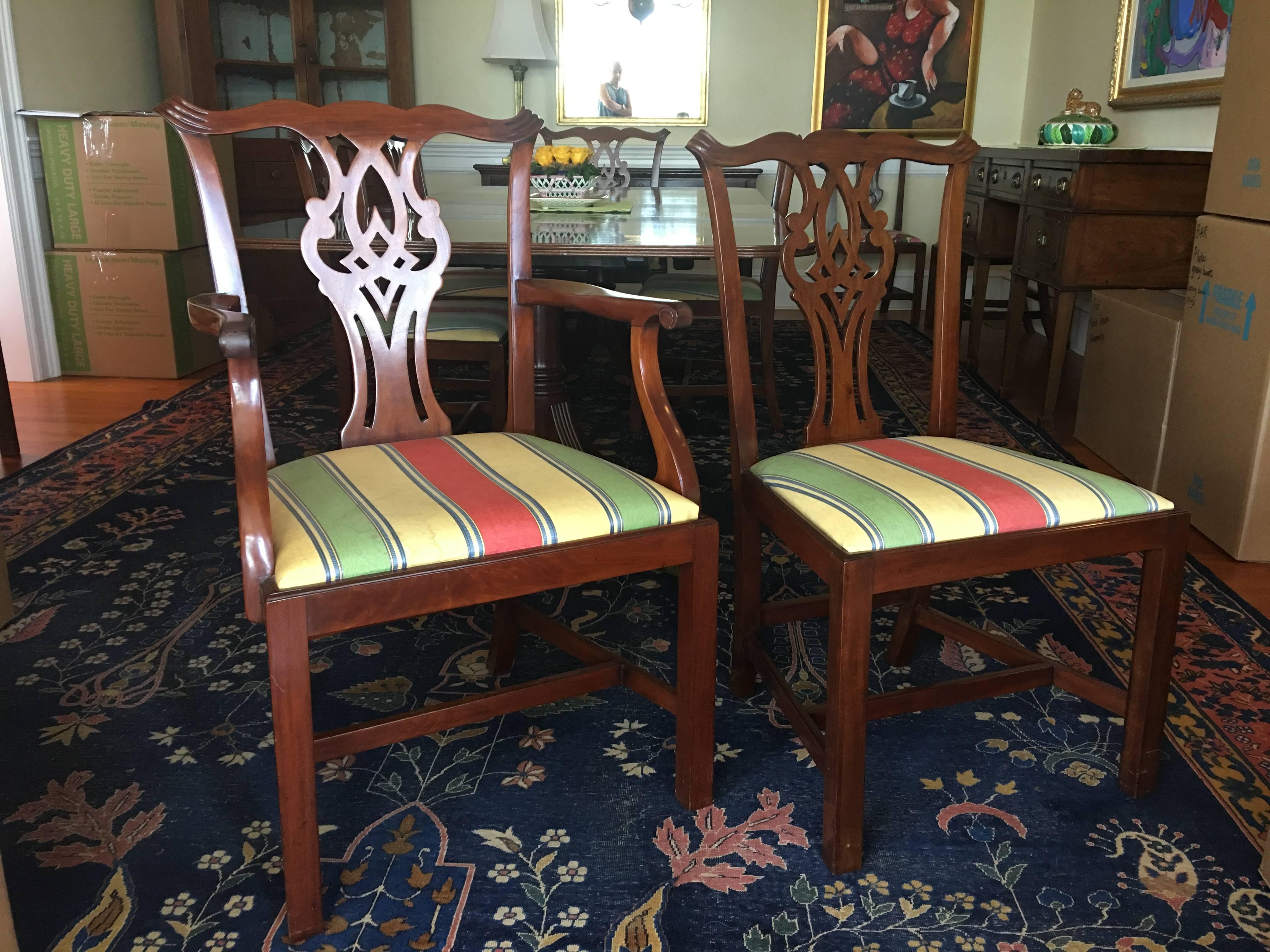 English set of Eight Chippendale style mahogany dining room chairs, circa 1870. Set includes two open armchairs and six side chairs, featuring a shaped horizontal crest rail with scrolled reeded ears, above a complex vasiform splat surmounting