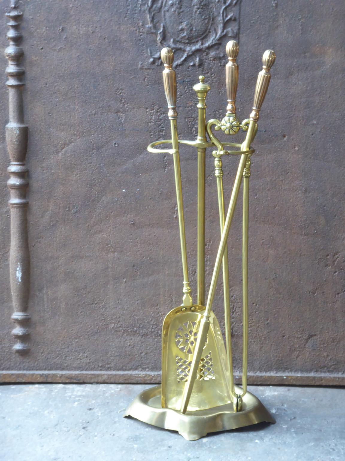 English set of three brass fireplace tools with copper handles and a brass stand. The fire tool set is in a good condition and is fully functional, 19th century, Victorian.
