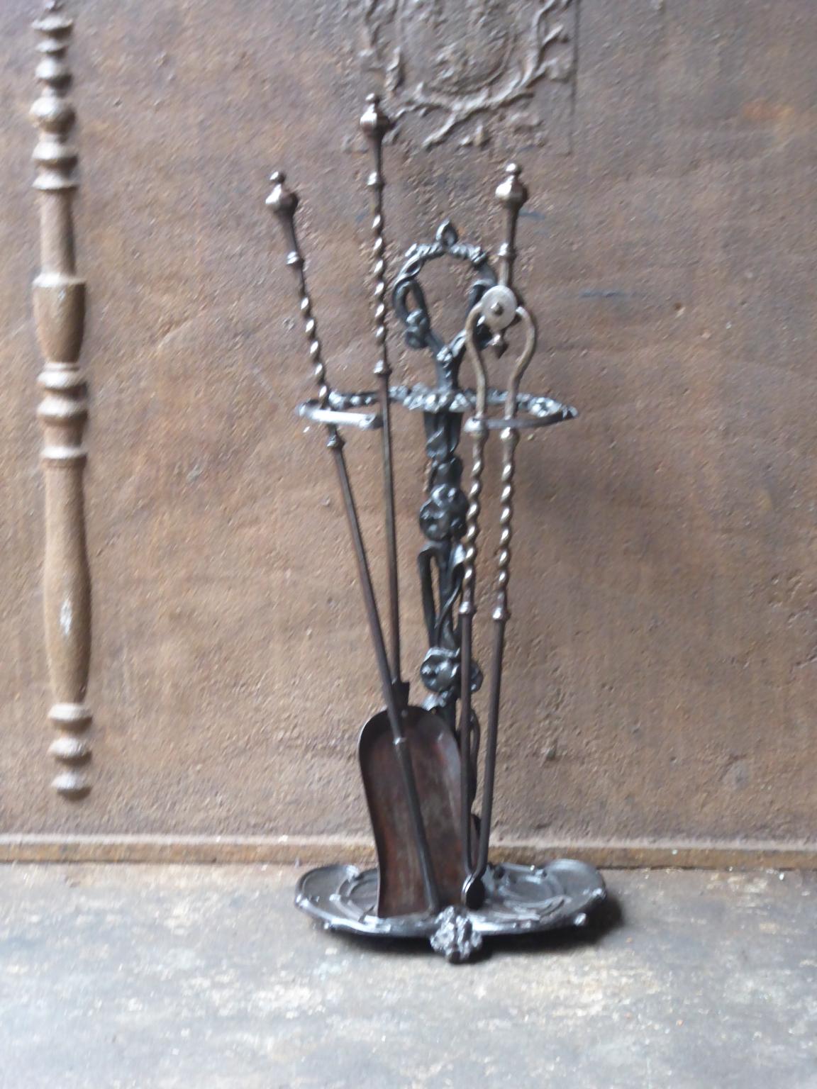 English set of three wrought iron fireplace tools with a stand made of cast iron. The fire tool set is in a good condition and is fully functional. 19th century, Victorian.