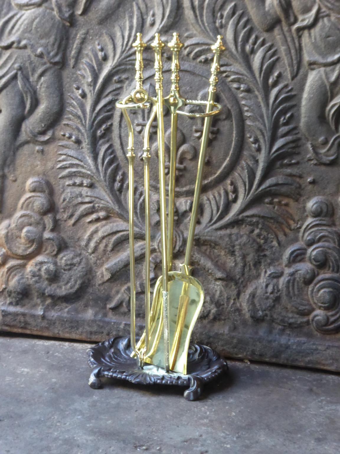 English set of three polished brass fireplace tools with a stand made of polished brass and cast iron. The fire tool set is in a good condition and is fully functional. 19th century, Victorian.