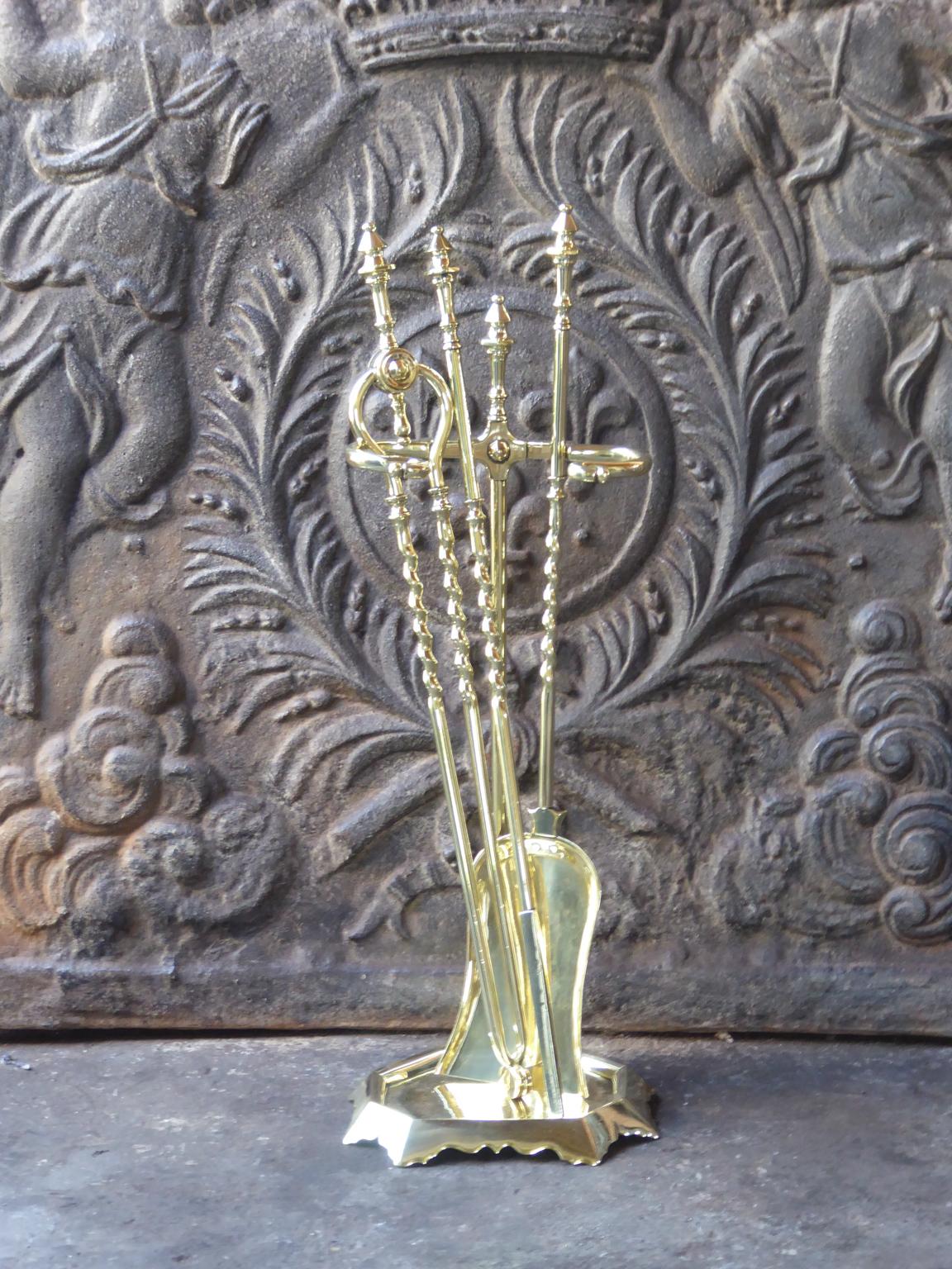 English set of three polished brass fireplace tools with a stand also made of polished brass. The fire tool set is in a good condition and is fully functional. 19th century, Victorian.