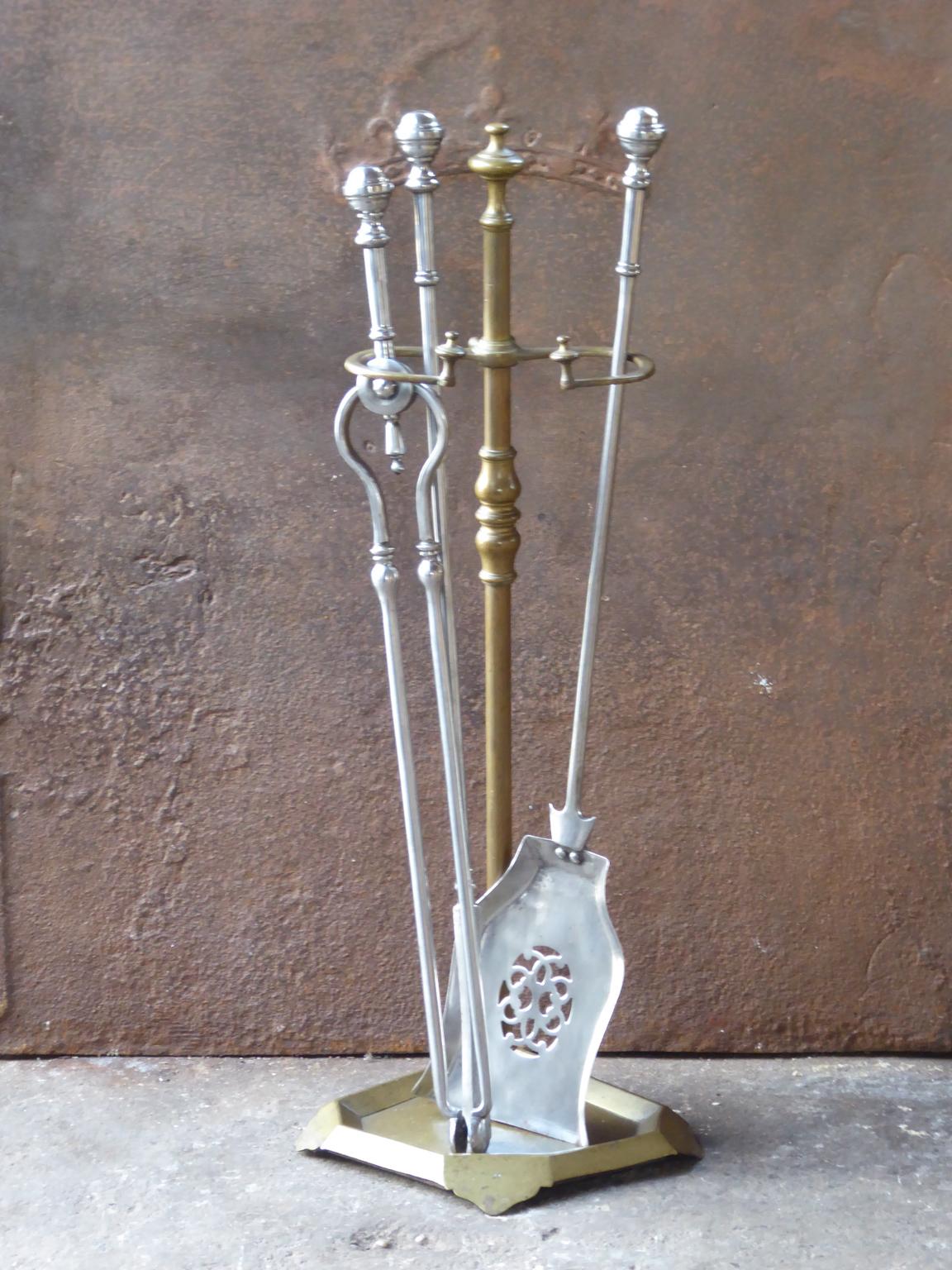 English set of three fireplace tools made of polished steel and with a stand made of brass. The fire tool set is in a good condition and is fully functional. 19th century, Victorian.