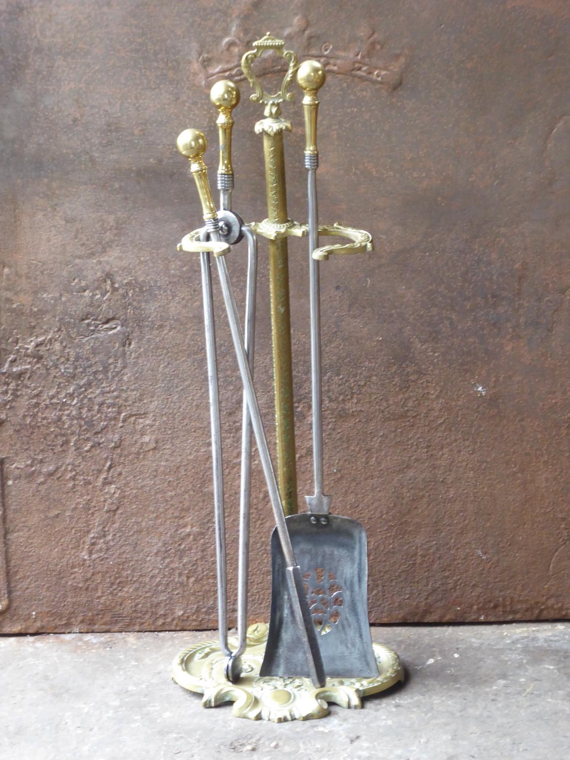 English set of three fireplace tools and a stand made of polished steel and brass. The fire tool set is in a good condition and is fully functional. 19th century, Victorian.