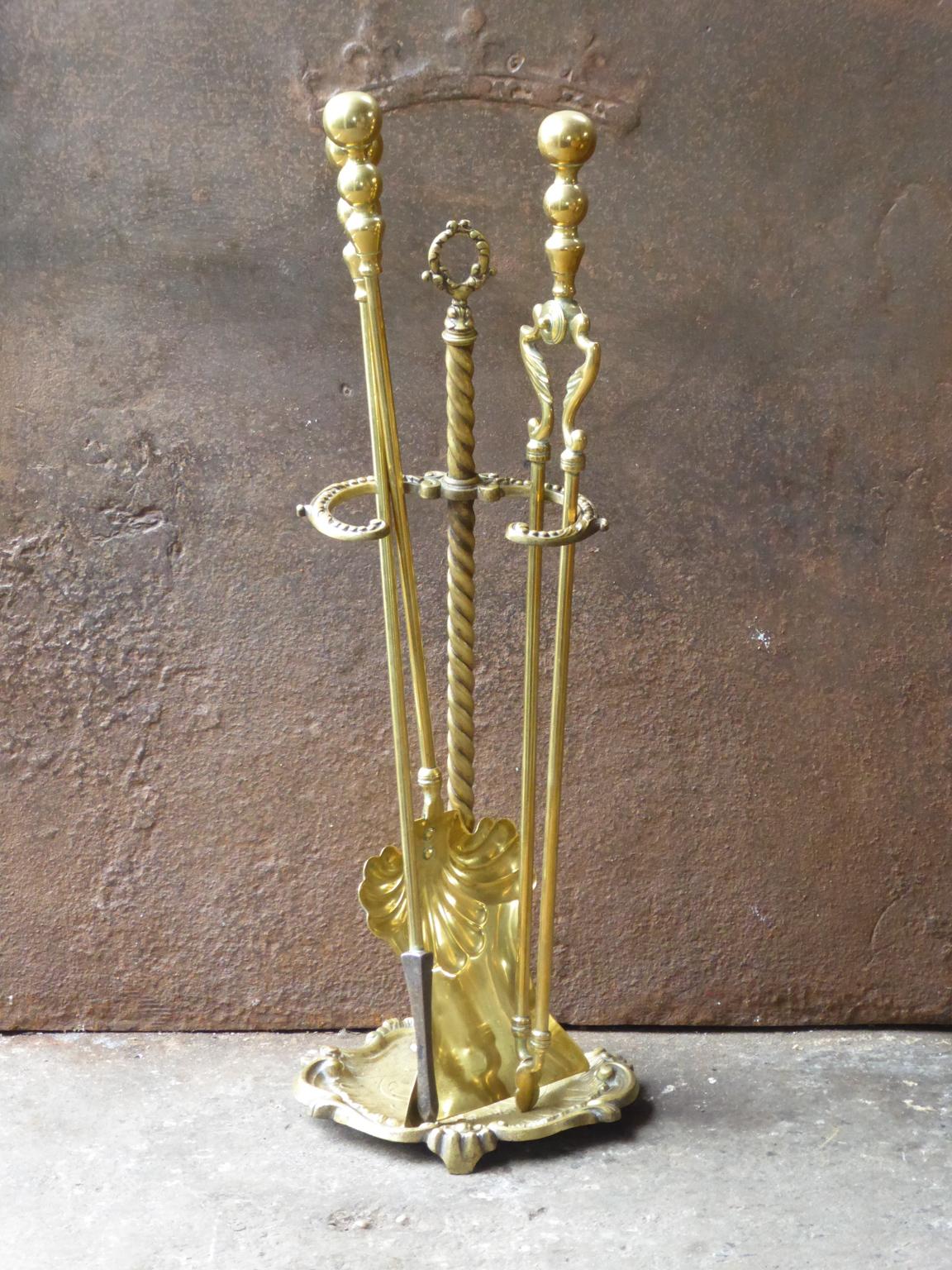 English set of three fireplace tools and a stand, made of brass. The fire tool set is in a good condition and is fully functional. 19th century, Victorian.
