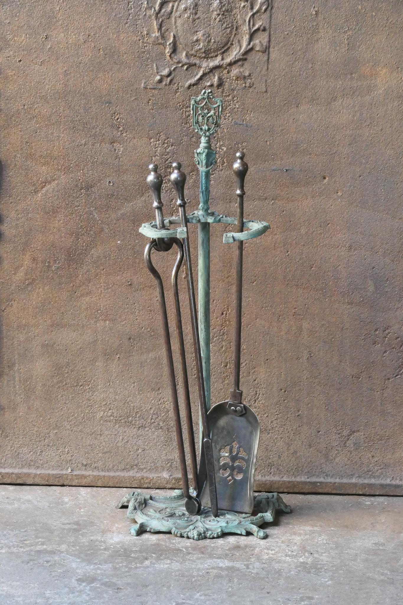 English set of three fireplace tools and a stand, made of wrought iron and brass. The fire tool set is in a good condition and is fully functional. 19th century, Victorian.