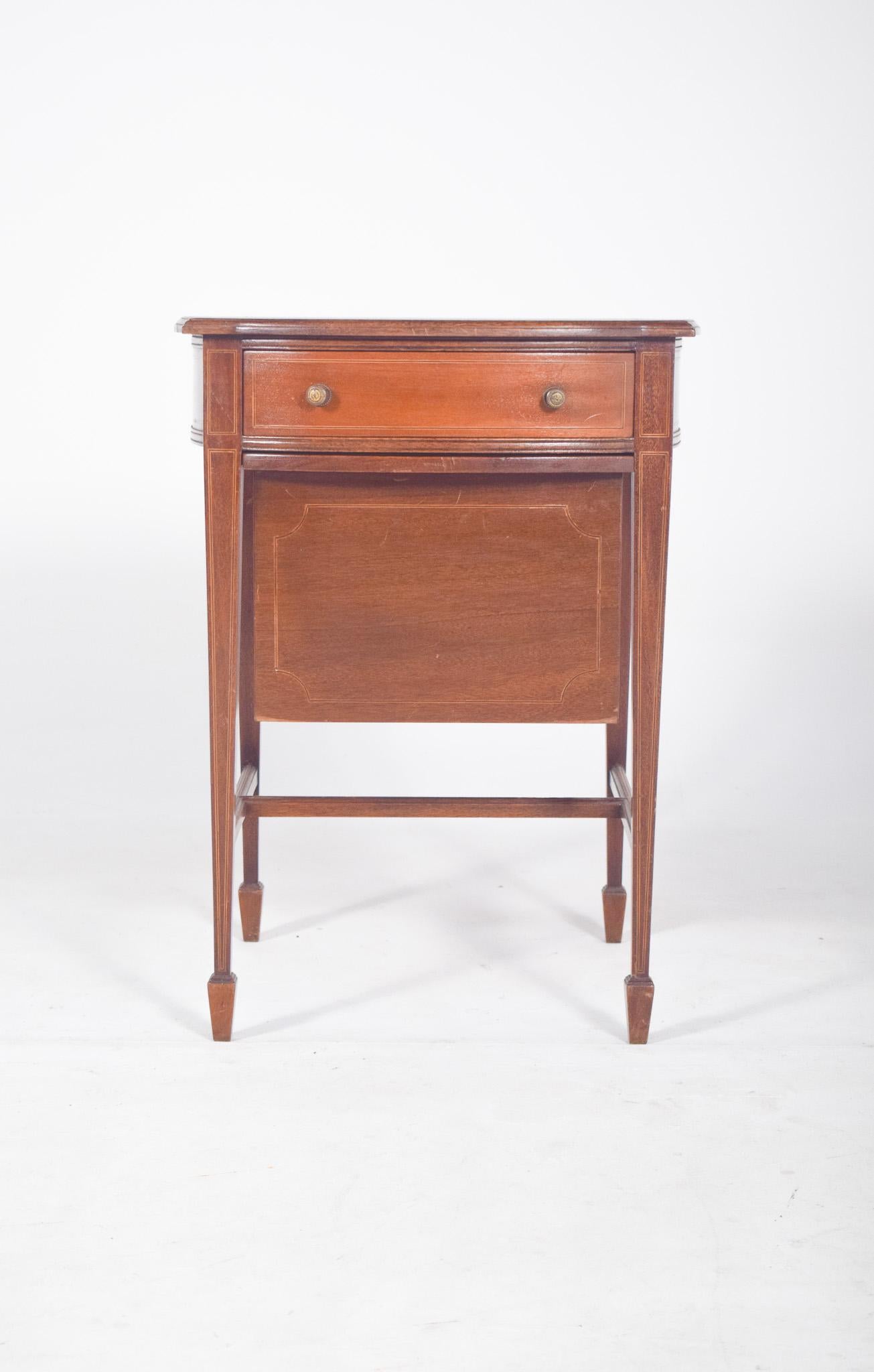 Sewing table with one drawer and one basket. With a light structure and straight lines, top with slightly curved sides and marquetry. The top drawer has internal dividers for organising small sewing objects and circular metal handles, while the