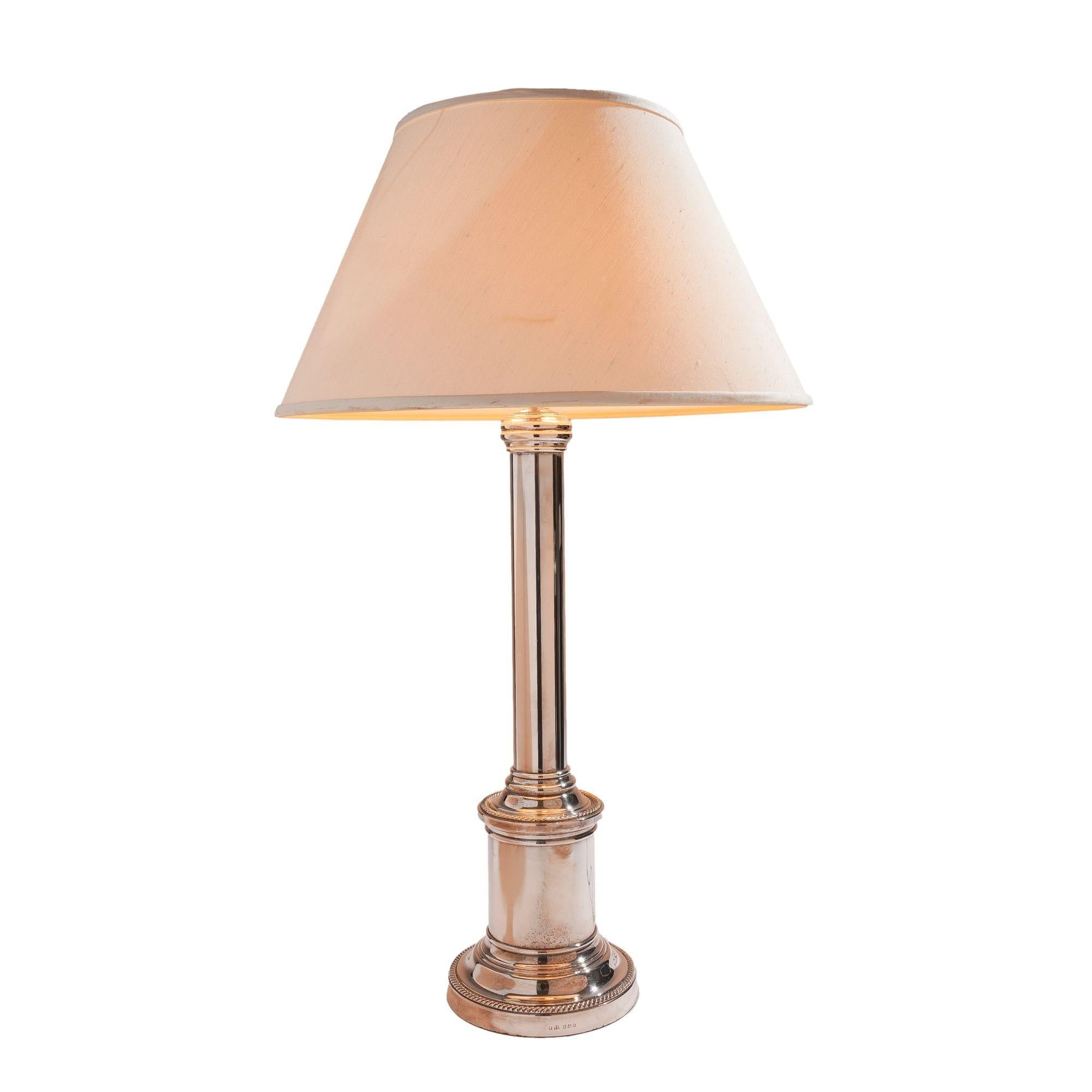 English hallmarked kerosene or oil banquet table lamp in silver plated nickel. The lamp is a doric column design with a gadroon edged drum form plinth on an extended gadroon edged circular foot. Electrified with silver plated brass double socket