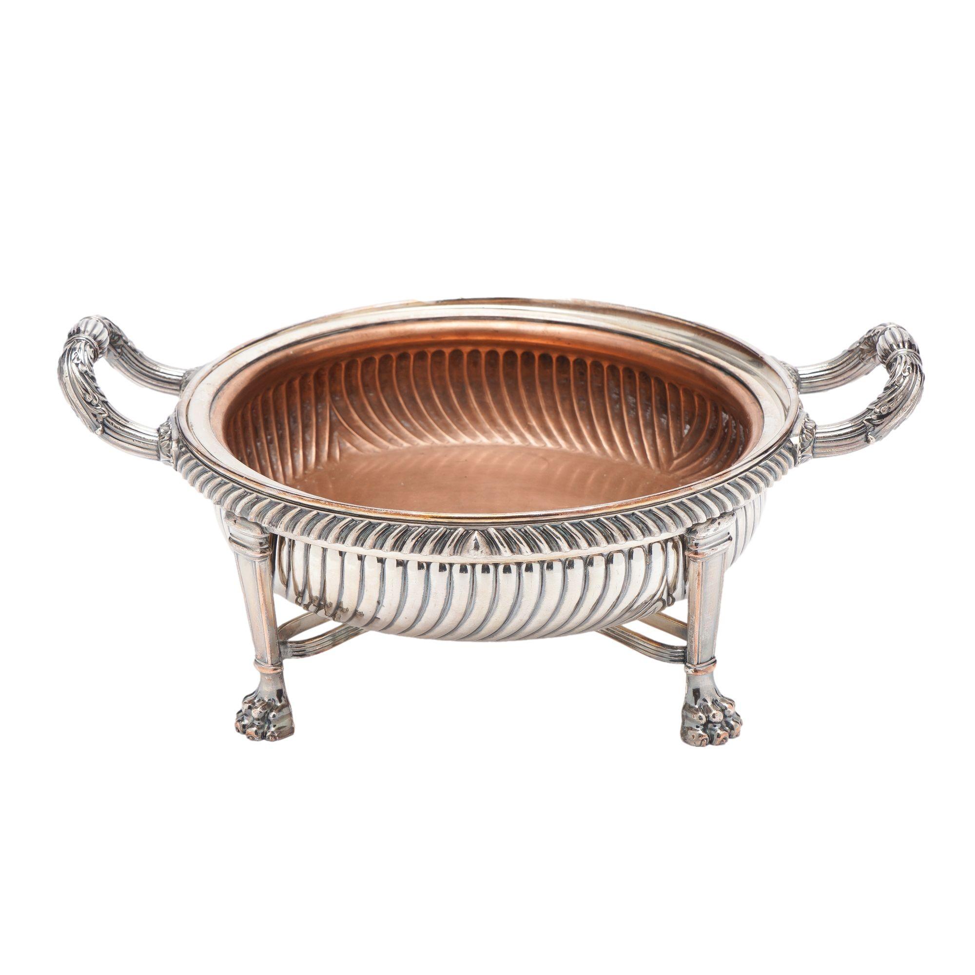 English Sheffield serving dish with fluted standing rim and drop fitted into a gadroon edge frame on four tapered pilaster legs on lion's paw feet The pilaster form legs are joined at the juncture with the paw feet by four, reeded arc stretchers.