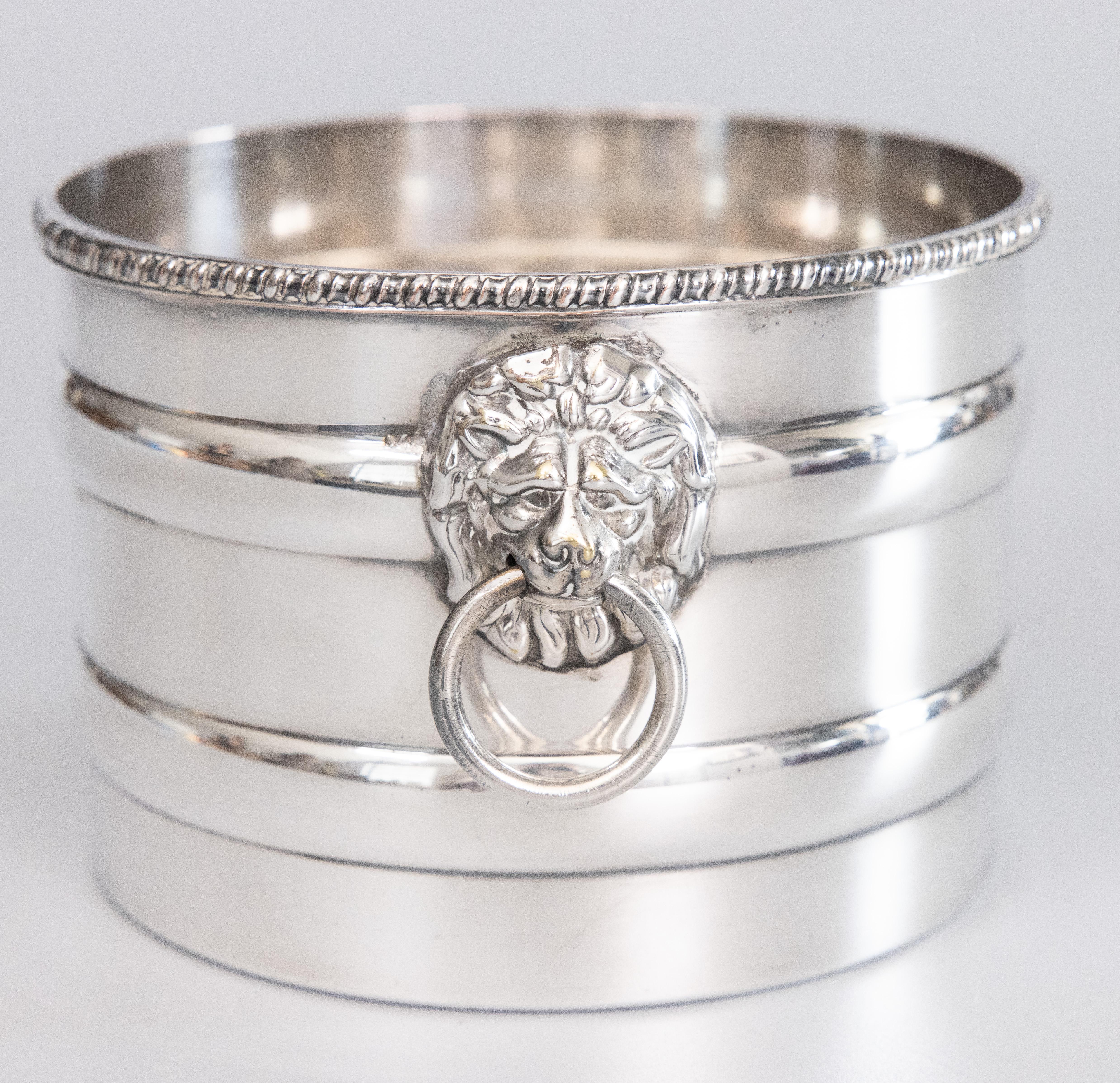 A lovely vintage mid-century English Sheffield Georgian style petite silverplate wine coaster or petite ice bucket with lion head ring handles. This fine quality ice bucket has exquisite details in the lion heads and decorative trim. It's the