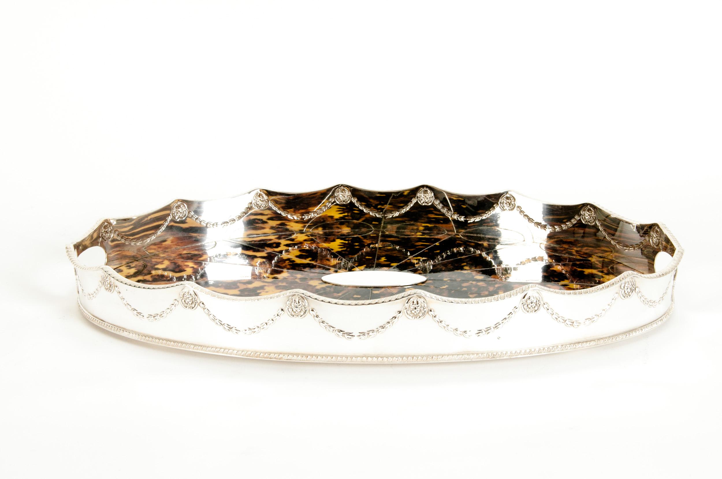 English Sheffield silver plated tortoiseshell interior barware / tableware footed serving tray with garland border design details. The tray is in great condition. Minor wear consistent with age / use. Maker's mark undersigned. The tray is about 20