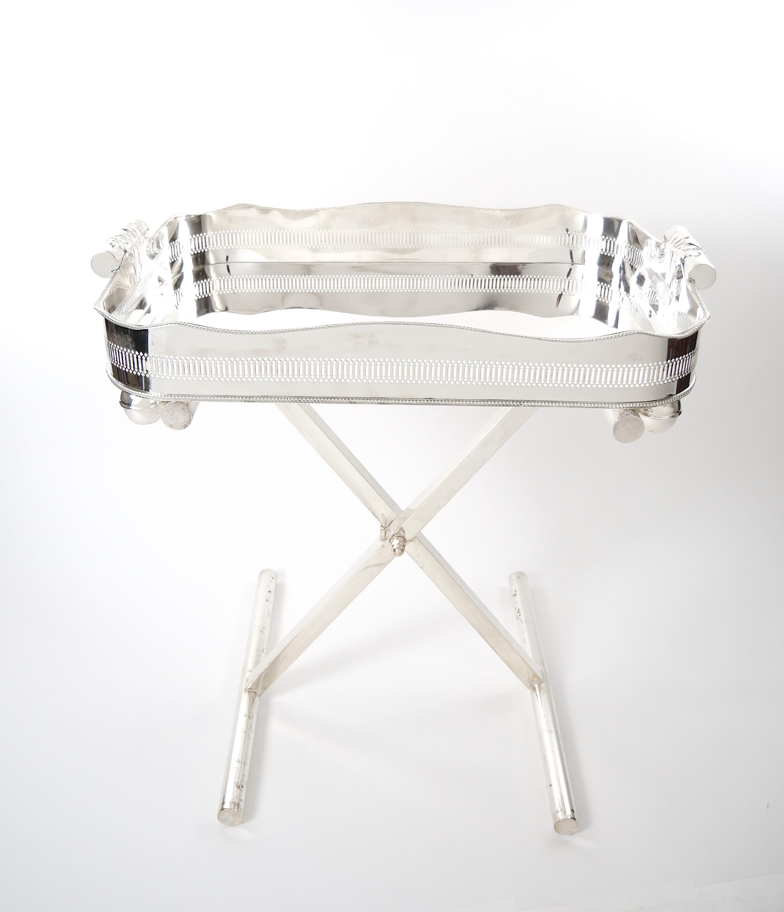 
Introduce a touch of timeless elegance to your entertaining space with this remarkable large English Sheffield silver plate art deco style high gallery folding serving tray on stand. Crafted with meticulous attention to detail, this piece