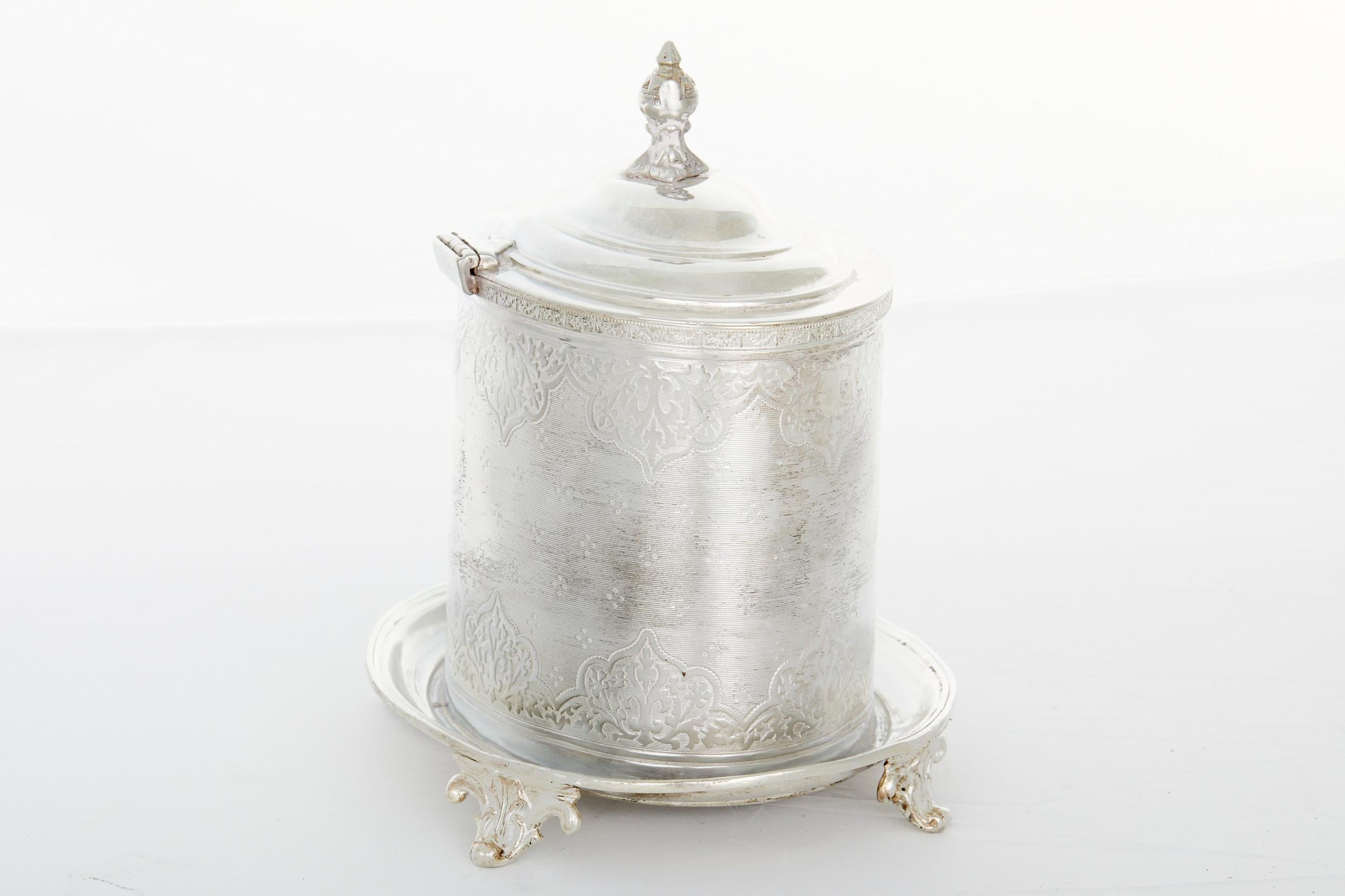English sheffield silver plate covered biscuit box / tea caddy with exterior design details and finial top cover . The tea caddy / box is in good condition . Minor wear consistent with age / use . Maker's mark undersigned . Minor bent to the holding
