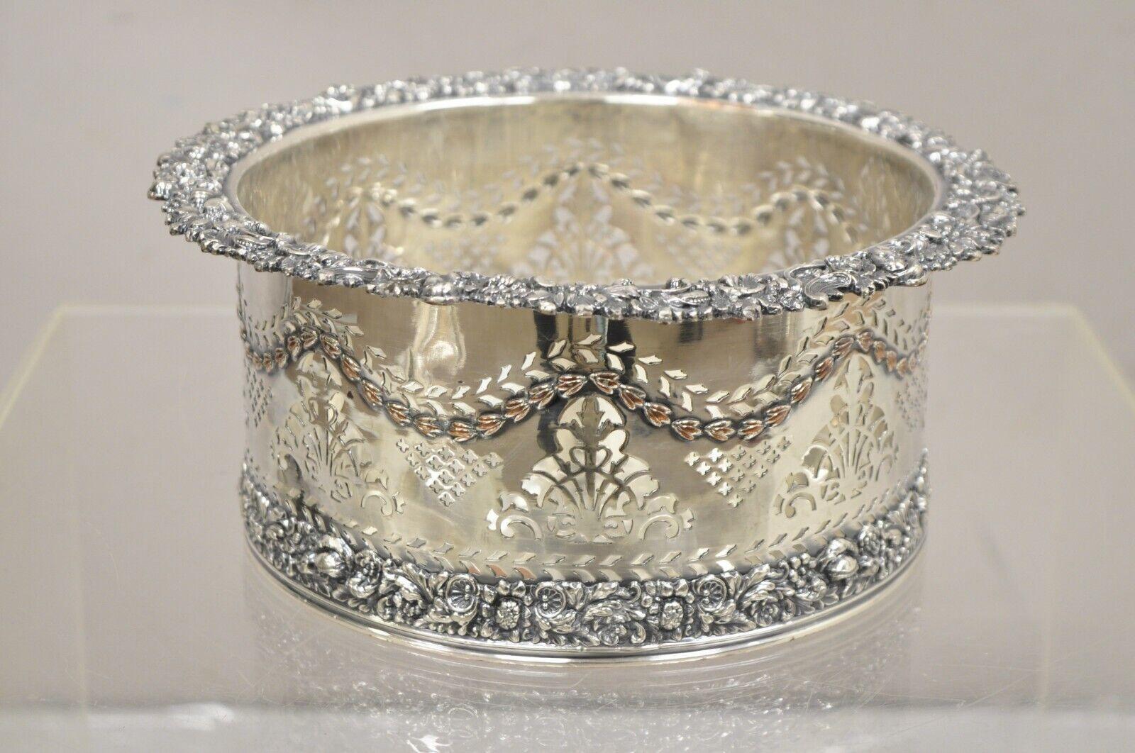 English Sheffield Sterling Silver Mounted Silver Plated Champagne Bottle Coaster. Item features floral pierced design with flower repoussé to base and rim, original hallmark, very nice antique item. Circa Early 1900s
Measurements:  4.5