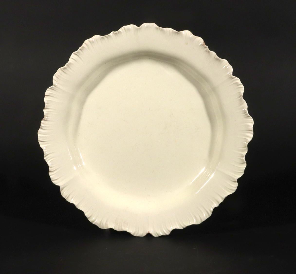 Cerámica inglesa con borde de concha  Placa,
Hacia 1775-85

El plato de cerámica de color crema tiene un borde ondulado y festoneado moldeado con el diseño conocido como borde de concha.  El color es excelente, con un glaseado crema