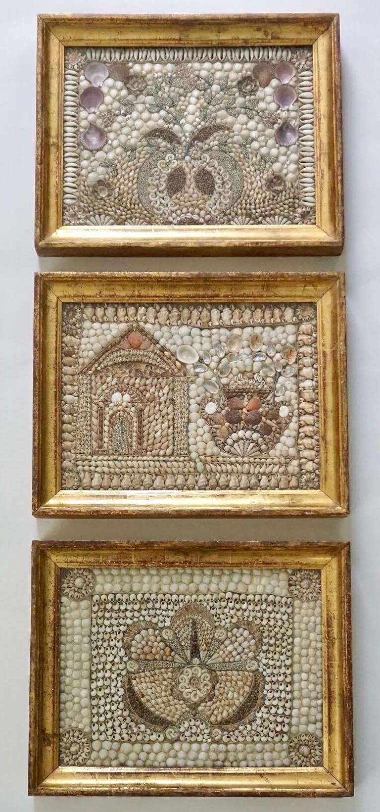An exquisite set of three English circa 1840 shellwork pictures in original giltwood frames composed of various Caribbean or West Indian seashells depicting fanciful designs of a foliated pomegranate, an Italianate temple and urn, and an ambiguous