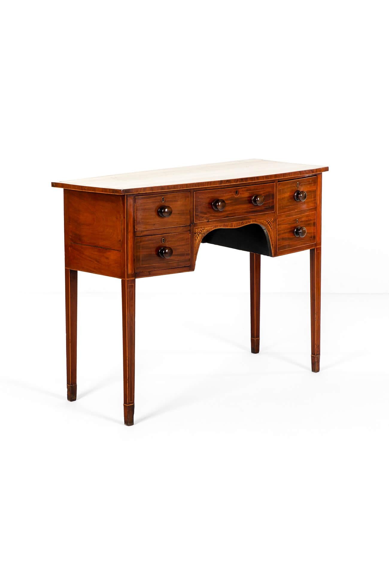An attractive Sheraton revival bowfront serving table in mahogany.

The gently over sailing top is detailed with a thin line marquetry tulip wood veneer to the boarder above a configuration of four drawers.

Each draw has brass escutcheons and