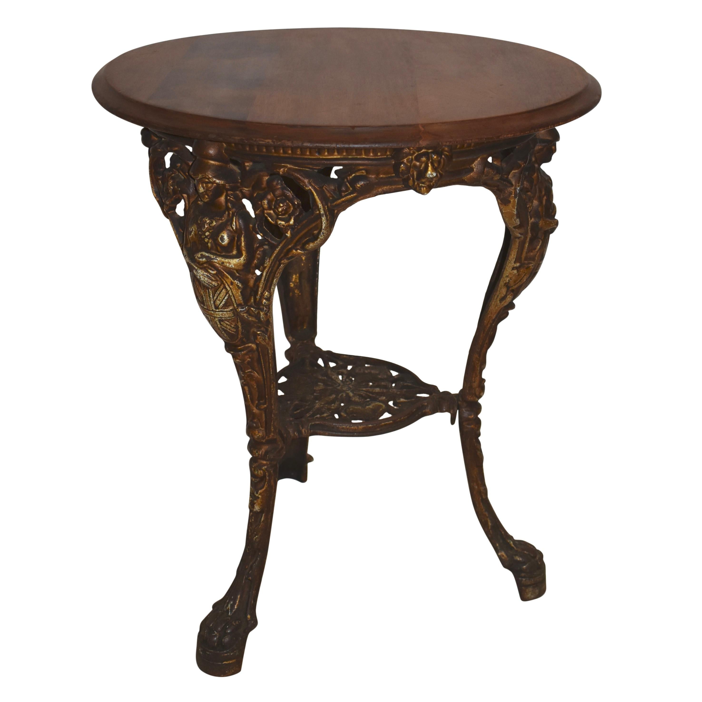 Comprised of a fruitwood top and iron base, this stunning side table features a refinished, beveled top secured to a tripod base with a lower pierced tier. The three cabriole legs terminate in paw feet. Britain's classic icon known as Britannia,