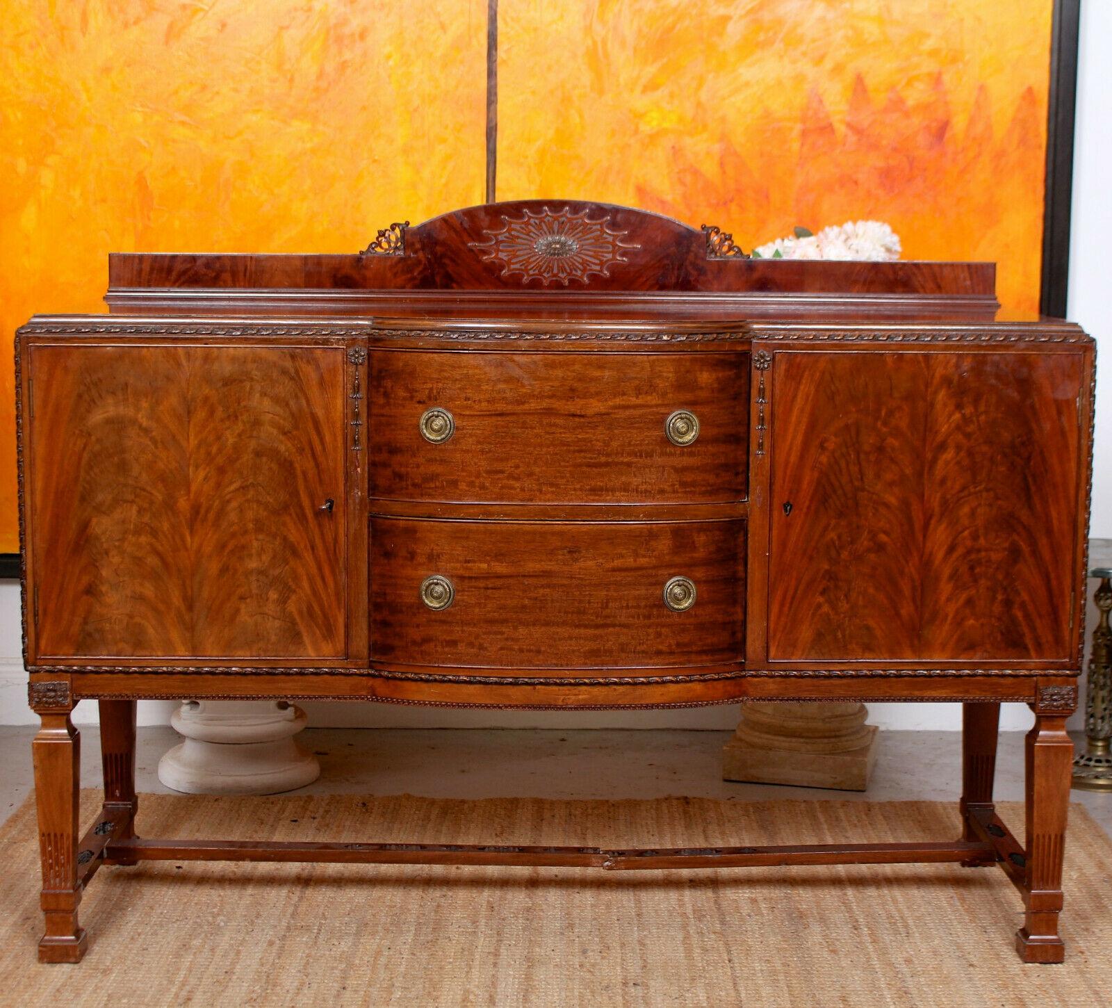 An attractive early 20th century sideboard.

The mahogany boasting a rich polished patina and well figured grain.

The raised gallery with sunburst motif above the shaped top with chamfered edges and carved detailing. A central bank of two