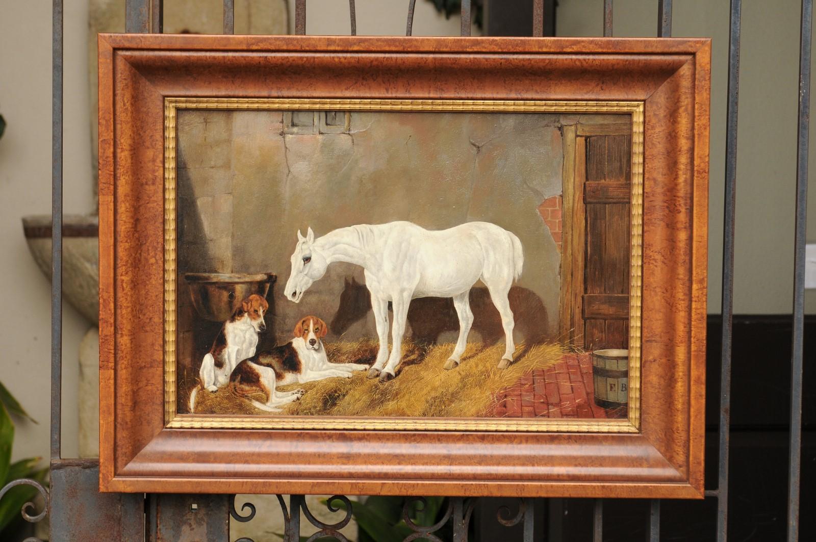  An English barn scene oil painting from the second half of the 19th century, depicting a white horse standing in the front of two hound dogs. This rustic scene strikes immediately by the sobriety of its palette mostly made of brown, red and yellow