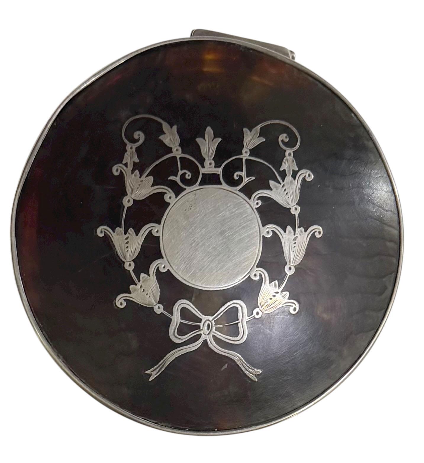 An elegant English Birmingham silver and tortoise shell box, hallmarked Birmingham, 1922, with maker’s mark L&S.

This refined piece features a faux tortoise shell lid beautifully inlaid with a sterling silver motif at its center, showcasing the