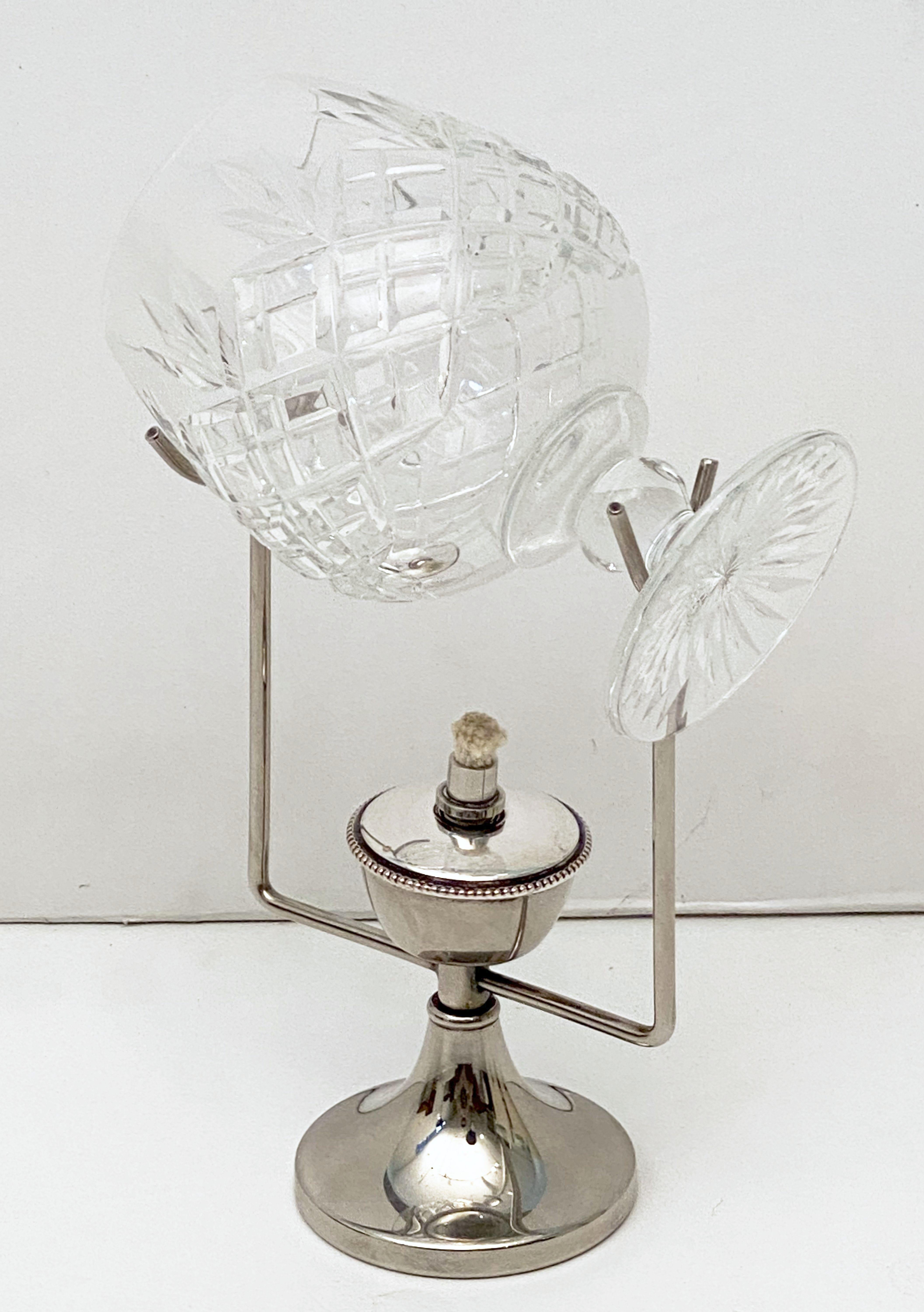 An English brandy glass warmer of fine silver plate, featuring a stand for the glass and spirit lamp below.
The spirit lamp is supplied with a wick.
The oil (not included) is added by unscrewing the top of the lamp.
The brandy cut glass snifter
