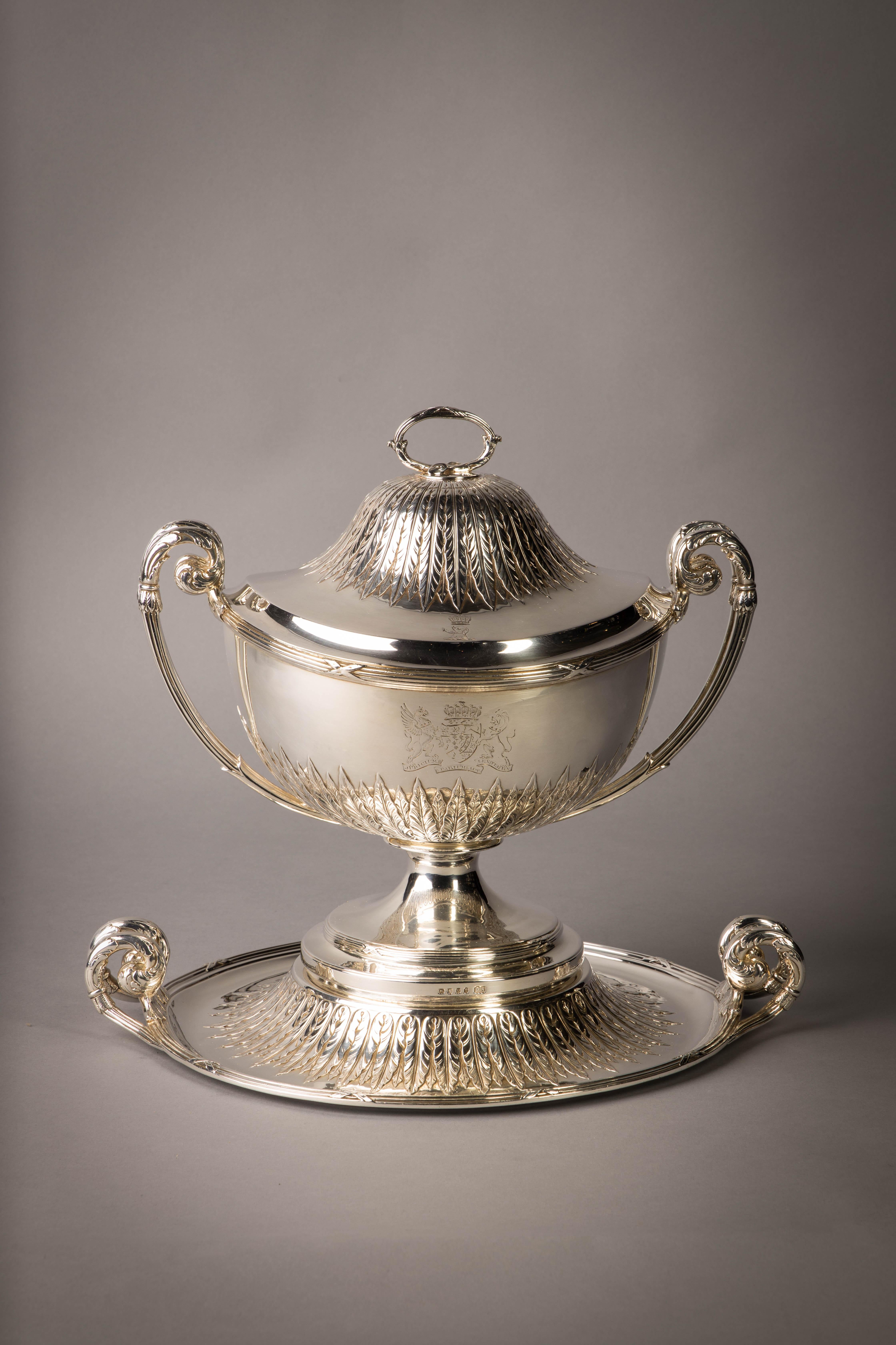 Une soupière en argent George III sur pied du service Camden. Marqué : Londres, 1794/1795. Créateur : Paul Storr. Sur un socle circulaire ciselé de feuilles de palmette, avec des bordures en roseau et deux poignées bifurquées, la coupe circulaire