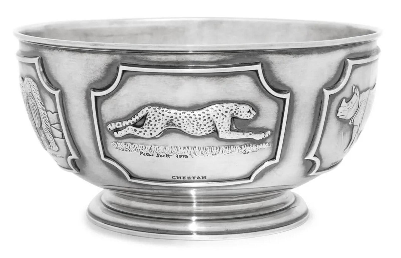 An English silver limited edition center bowl from Tessier Ltd., London with relief panels of various endangered species, including the Polar Bear by Robert Bateman, Cheetah by Peter Scott, Arabian Oryx by Keith Shackleton, and Tiger by Raymond