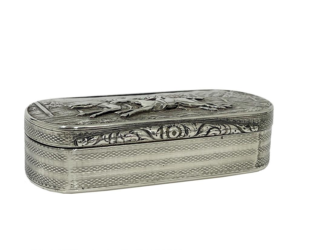 English silver horse racing snuff box, Birmingham 1829

A silver snuff box with a scene from horse racing on top of the hinged lidded box. On the sides a guilocche pattern and inside the box a gilded interior. The snuffbox has the Silver hall marks