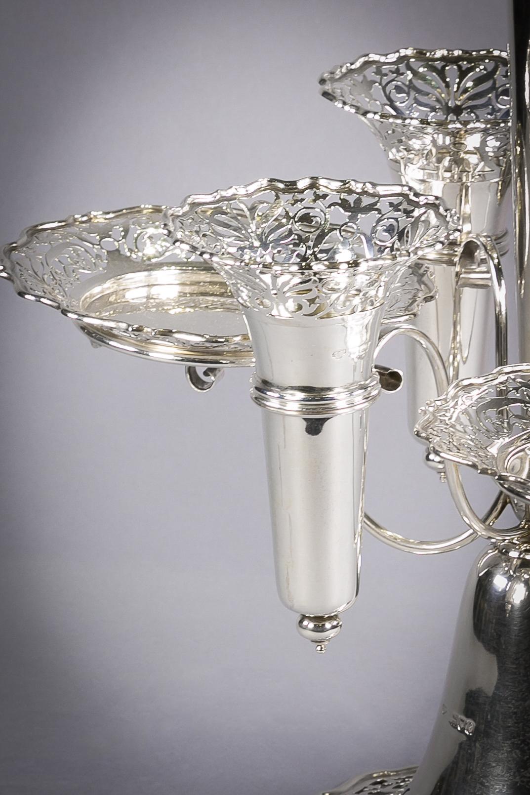 Consisting of three dishes and three vases surrounding a large center vase. Marked: London, 1901, Goldsmiths and Silversmiths company.