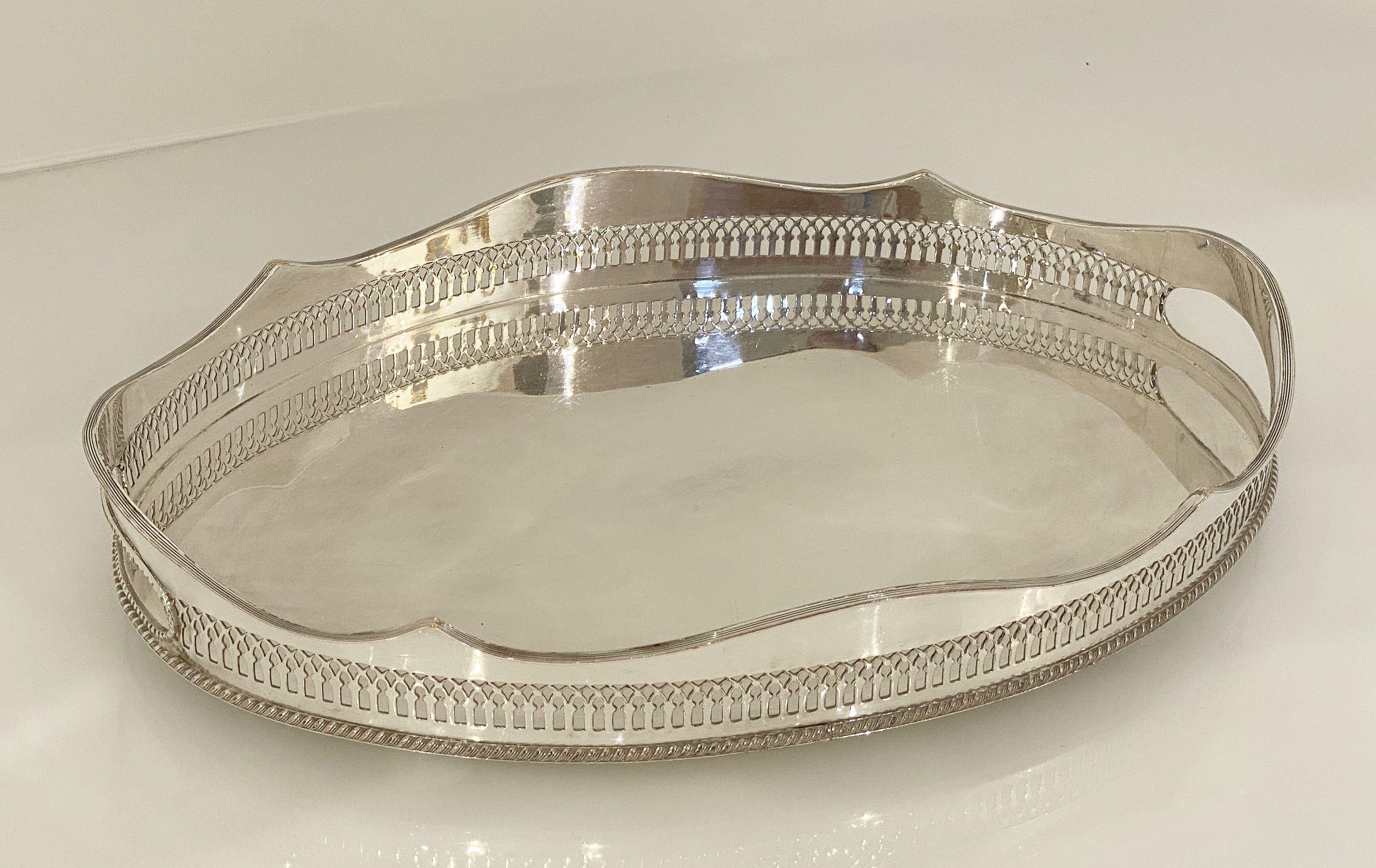 A handsome English oval gallery serving or drinks tray (or platter) of fine plate silver - featuring a pierced serpentine gallery with a distinctive design around the circumference.

Dimensions: Gallery H 2 1/2 inches x W 14 5/8 inches x D 10 1/8
