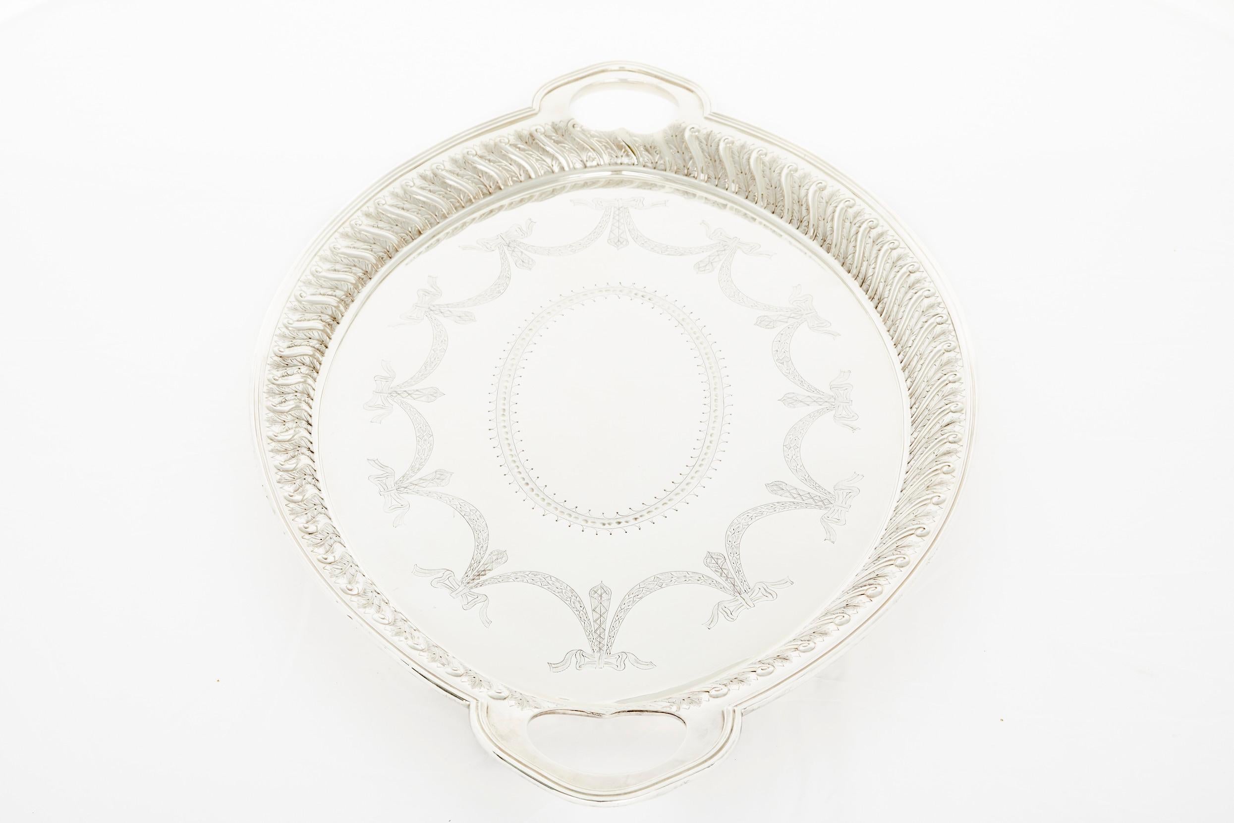 Large and heavy, Edwardian style, Silver plated barware / tableware serving Tray. The tray features flat chased interior and exterior floral, scroll decoration to the body with a shaped shell and gadroon border, and an engraved crest and two side