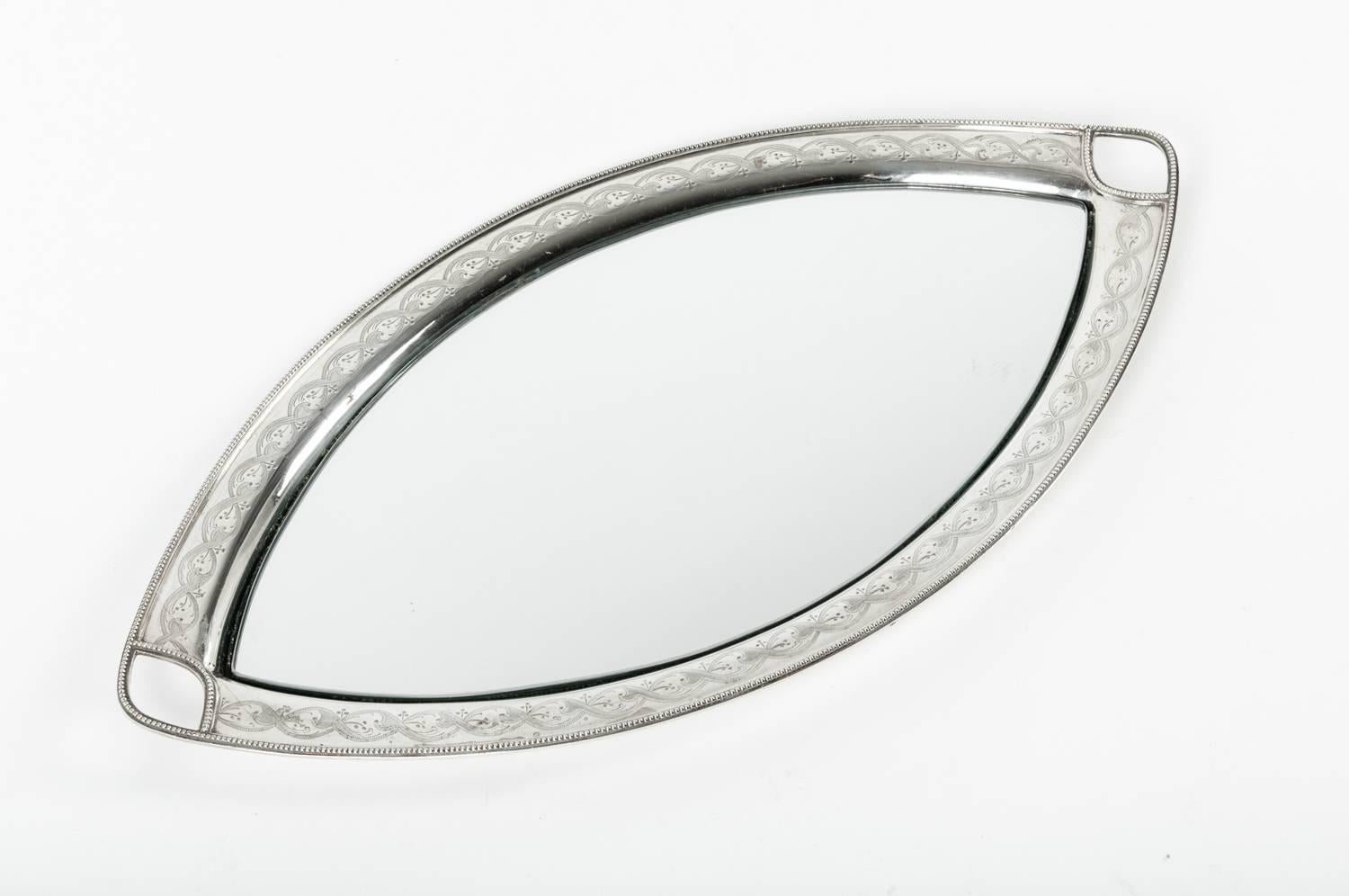 English silver plate footed oval shape with side handles vanity tray with mirror insert & exterior design details. The tray is great condition, minor wear consistent with age / use. Maker's mark undersigned. The tray measures about 21 inches long x