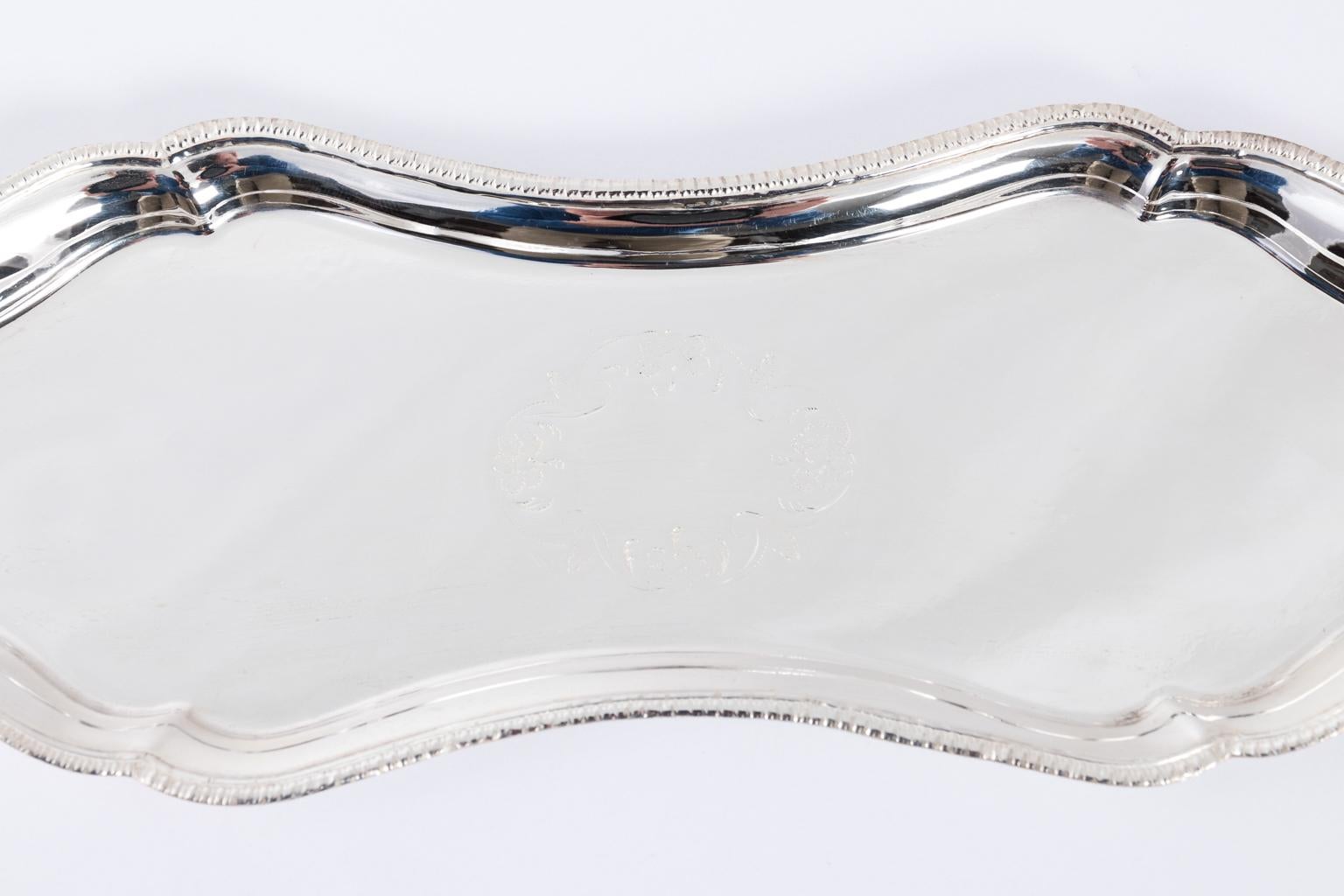 English silver plate pen tray with rounded corners and decorative etched scrolls at the centre.
  